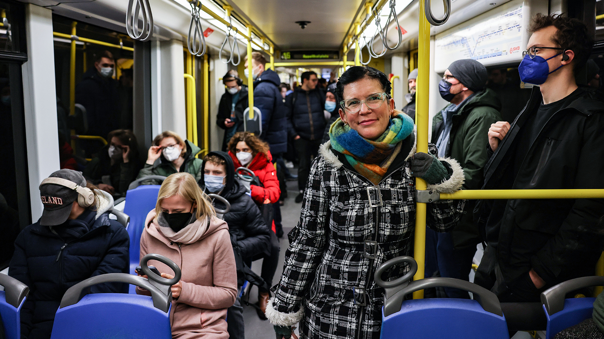 Eine Frau steht ohne Maske in der U-Bahn.