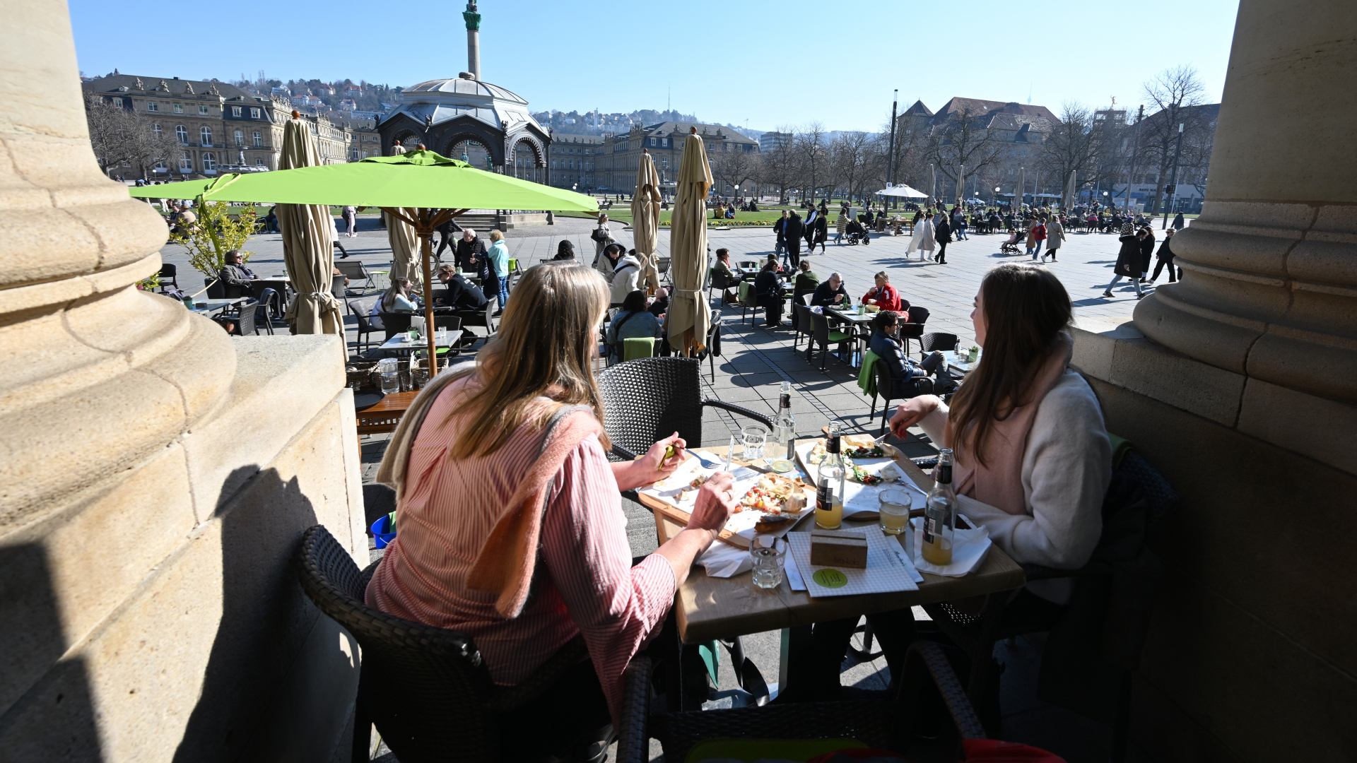 Bei strahlendem Sonnenschein sitzen Passanten in einem Straßencafe in Stuttgart | dpa