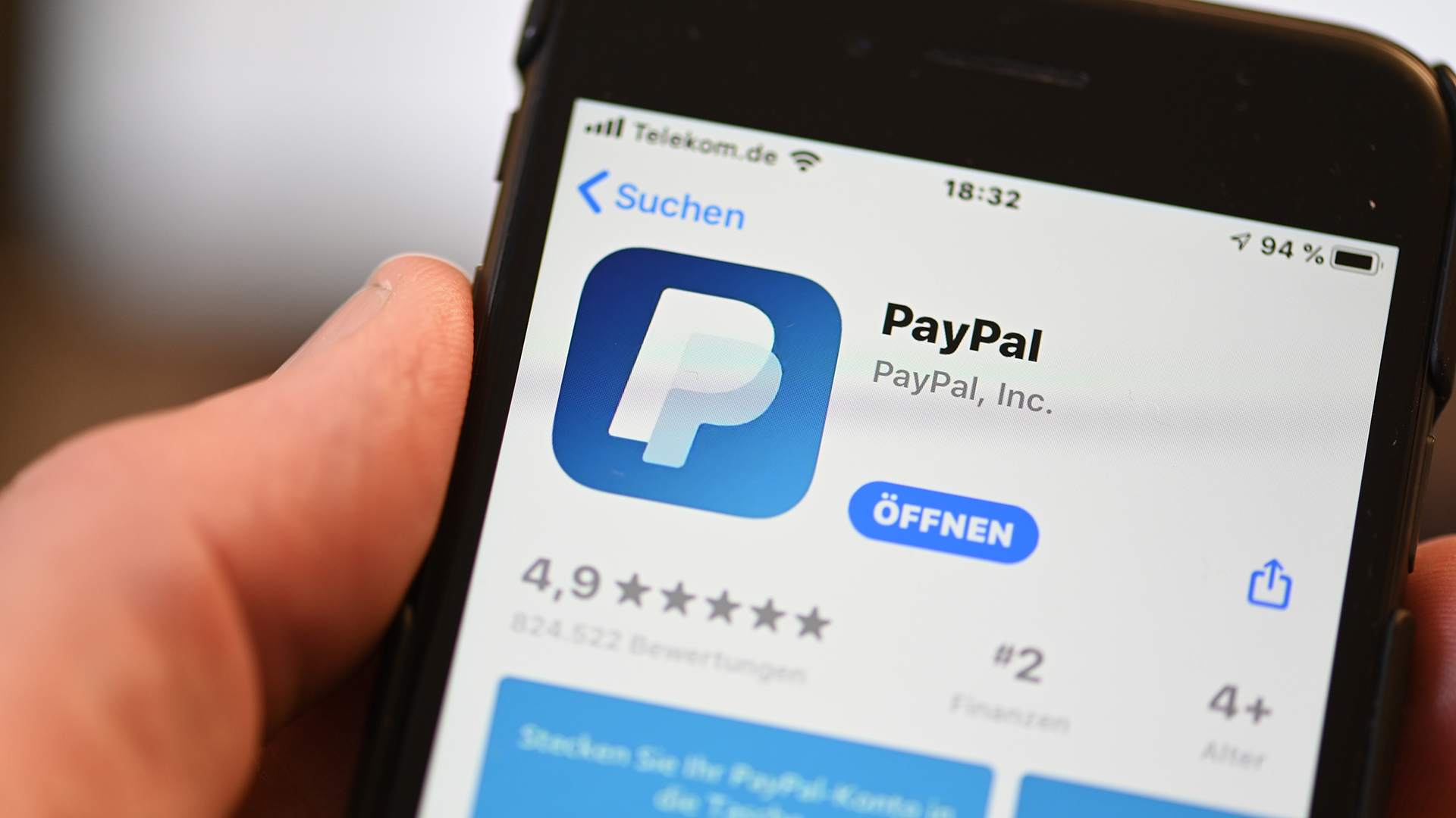 Die Applikation von PayPal ist auf einem Mobilfunkgerät zu sehen, das ein Mann in der Hand hält. | dpa