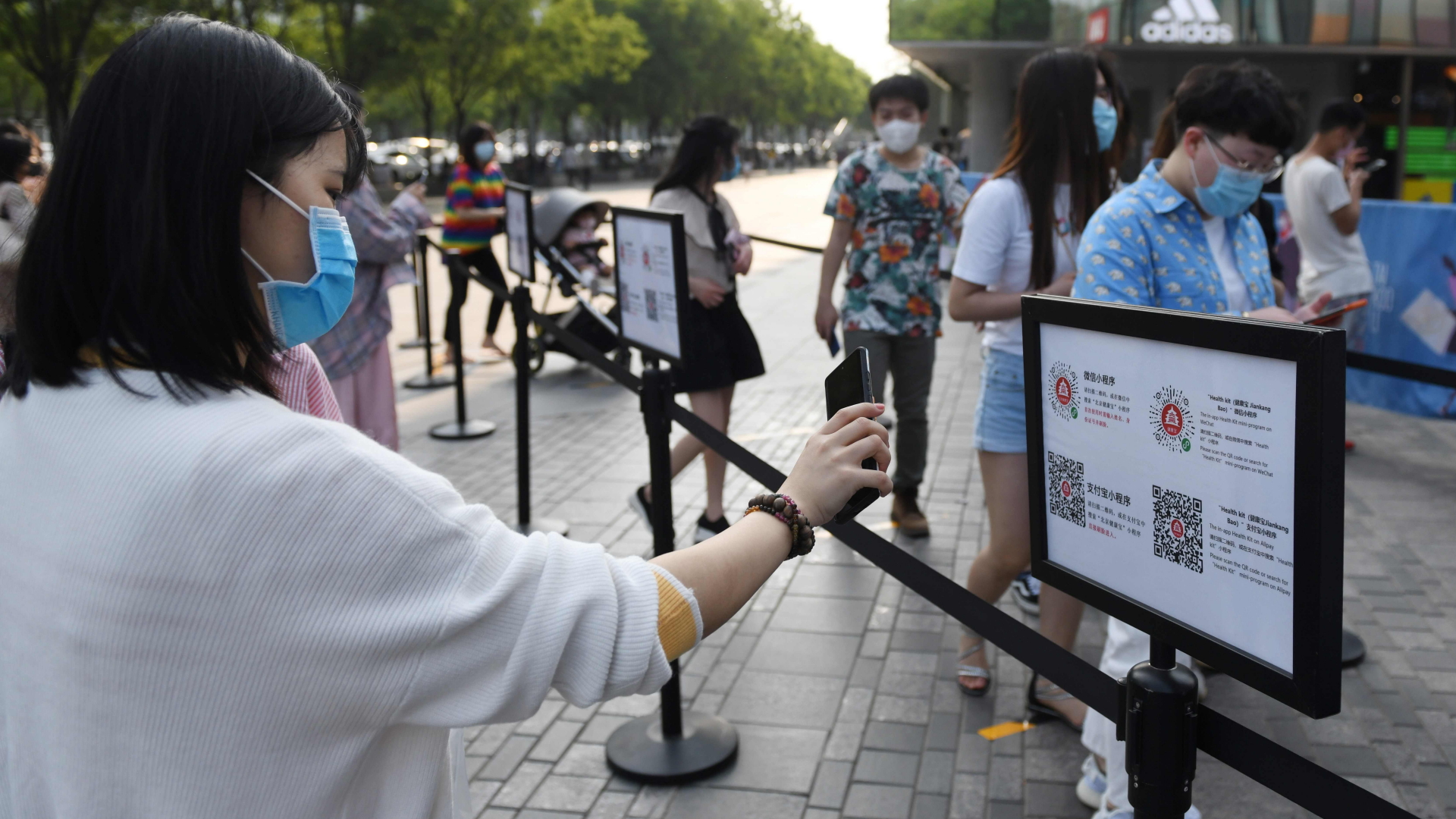Eine Frau in Peking scannt mit ihrem Handy einen QR-Code, um ihren Gesundheitszustand überprüfen zu lassen. | AFP