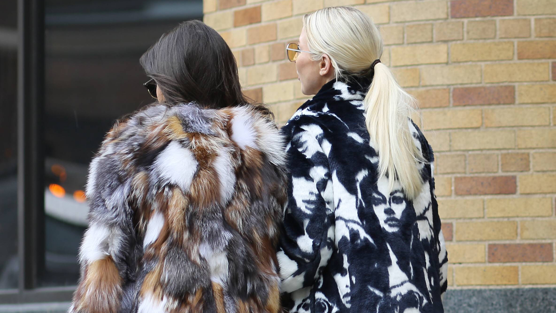 Zwei Frauen gehen nebeneinander eine Straße entlang - eine davon in einer Pelzjacke . | imago/Runway Manhattan