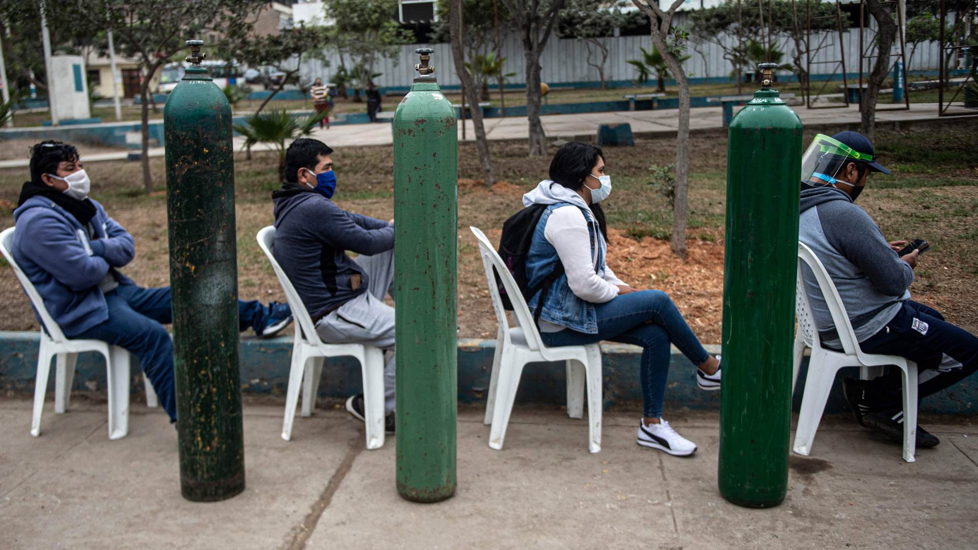Menschen warten in einer Reihe, um ihre Sauerstoffbehälter wieder aufzufüllen. | AFP