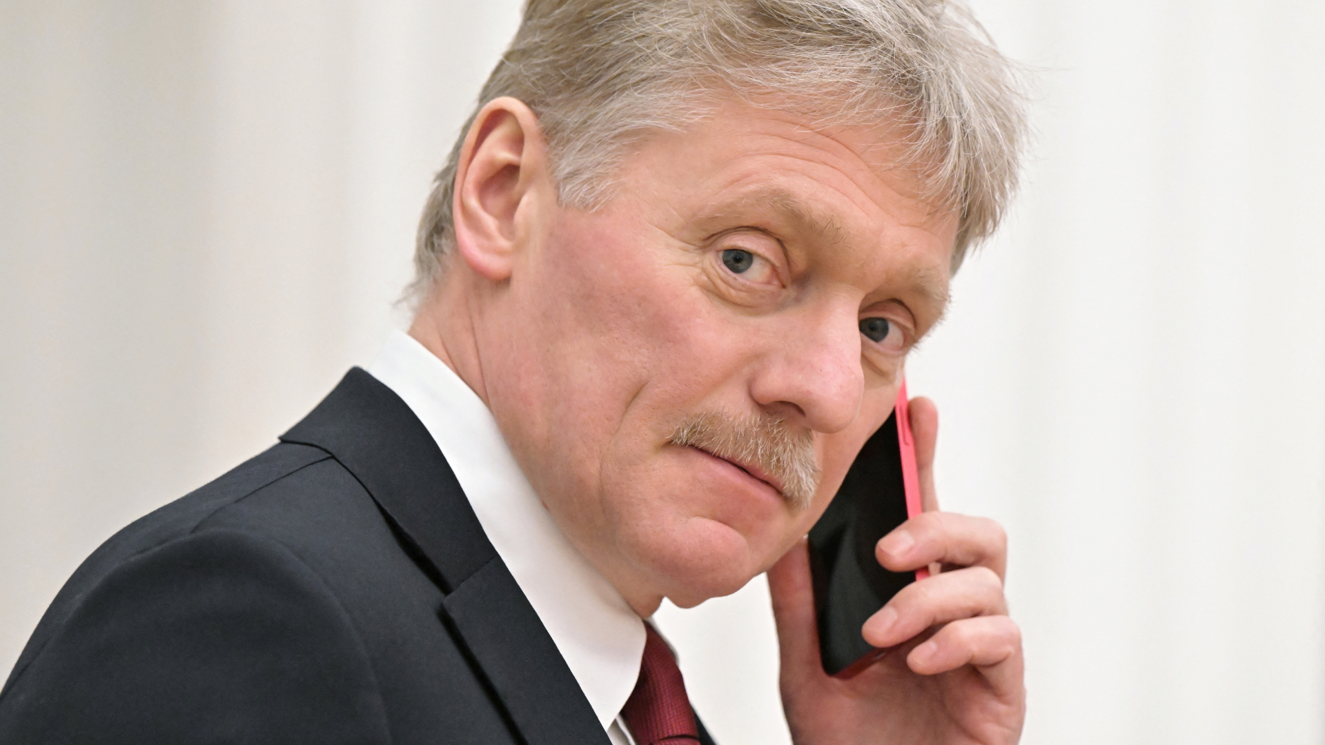 Kreml-Sprecher Peskow mit einem Smartphone am Ohr. | via REUTERS