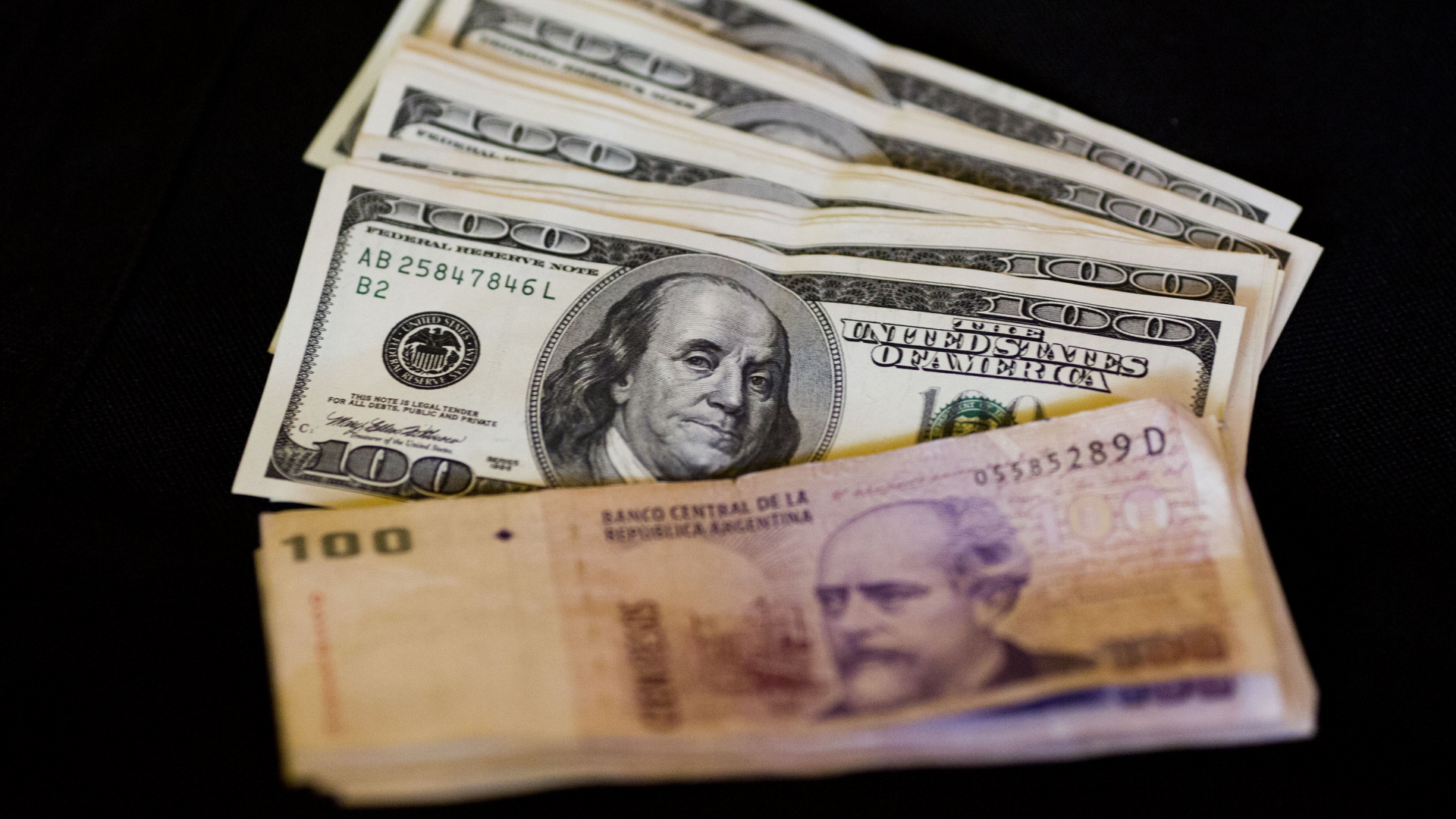 Ein Bündel Pesos liegt vor Dollarnoten | AP