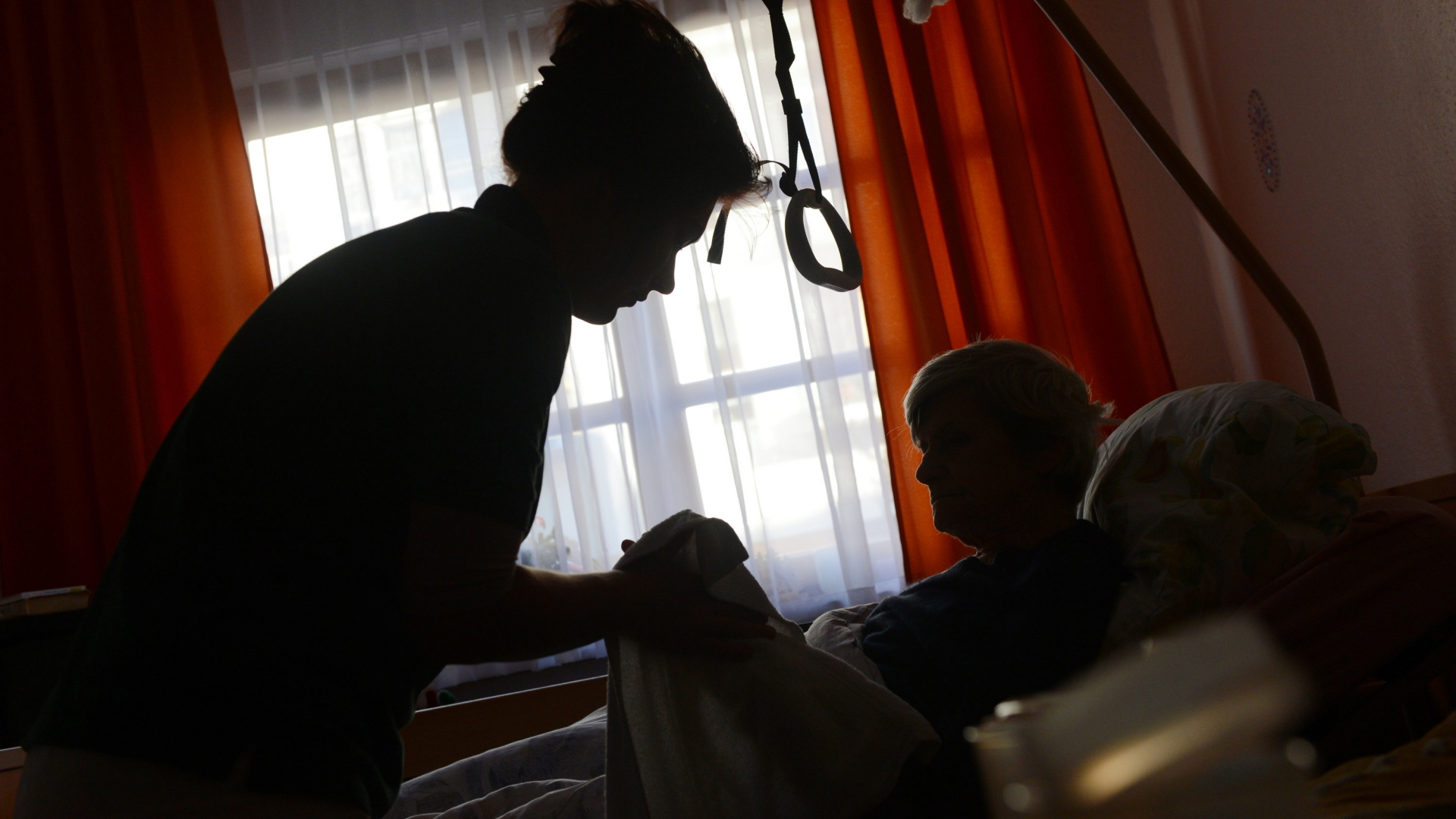Eine Frau wird in einem Seniorenpflegeheim von einer Pflegerin betreut.