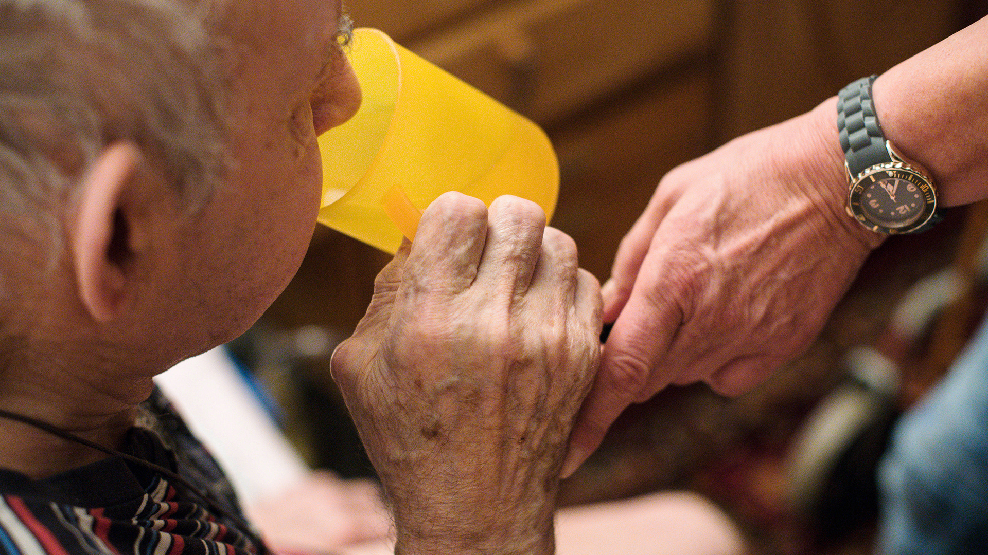 Eine ambulante Pflegerin hilft einem alten Mann bei der Tabletteneinnahme. | dpa