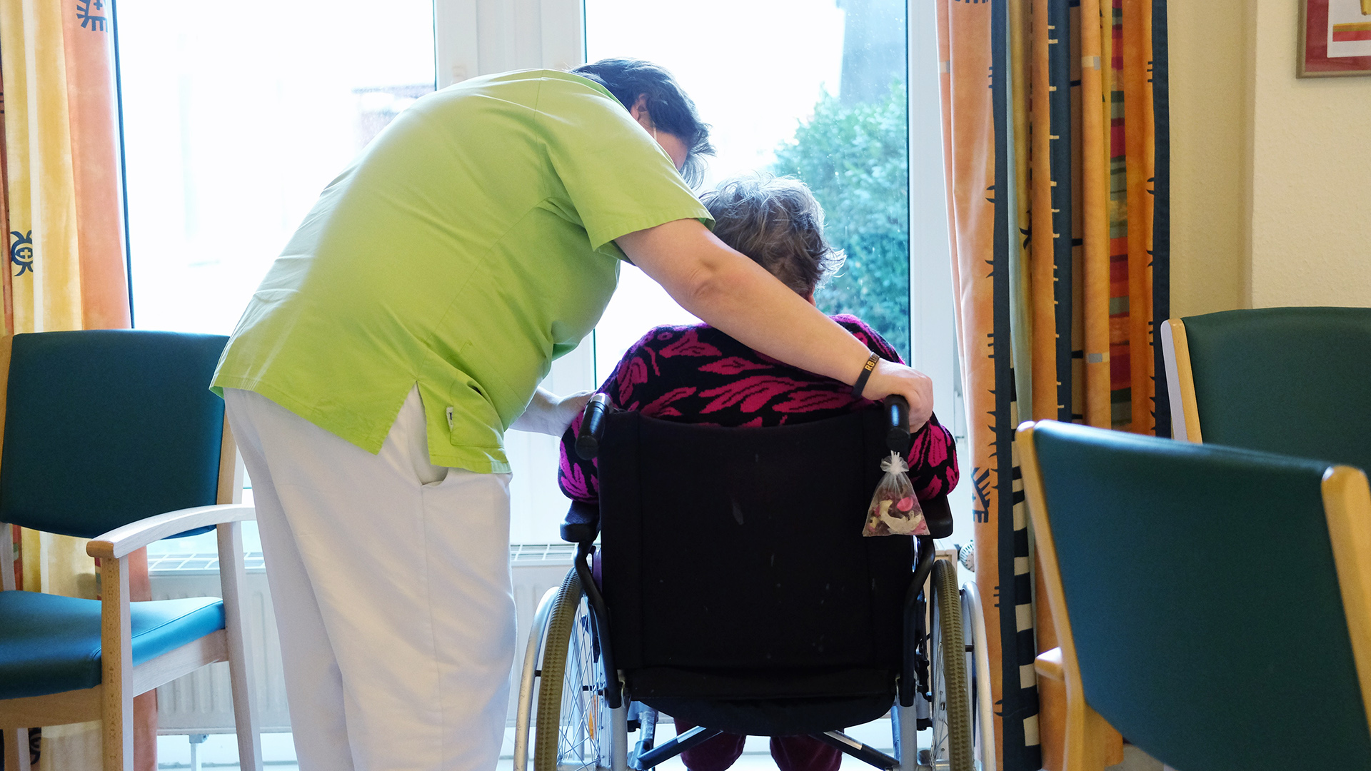 Eine Pflegerin spricht mit der Bewohnerin eines Pflegeheimes. | picture alliance/dpa/dpa-Zentral