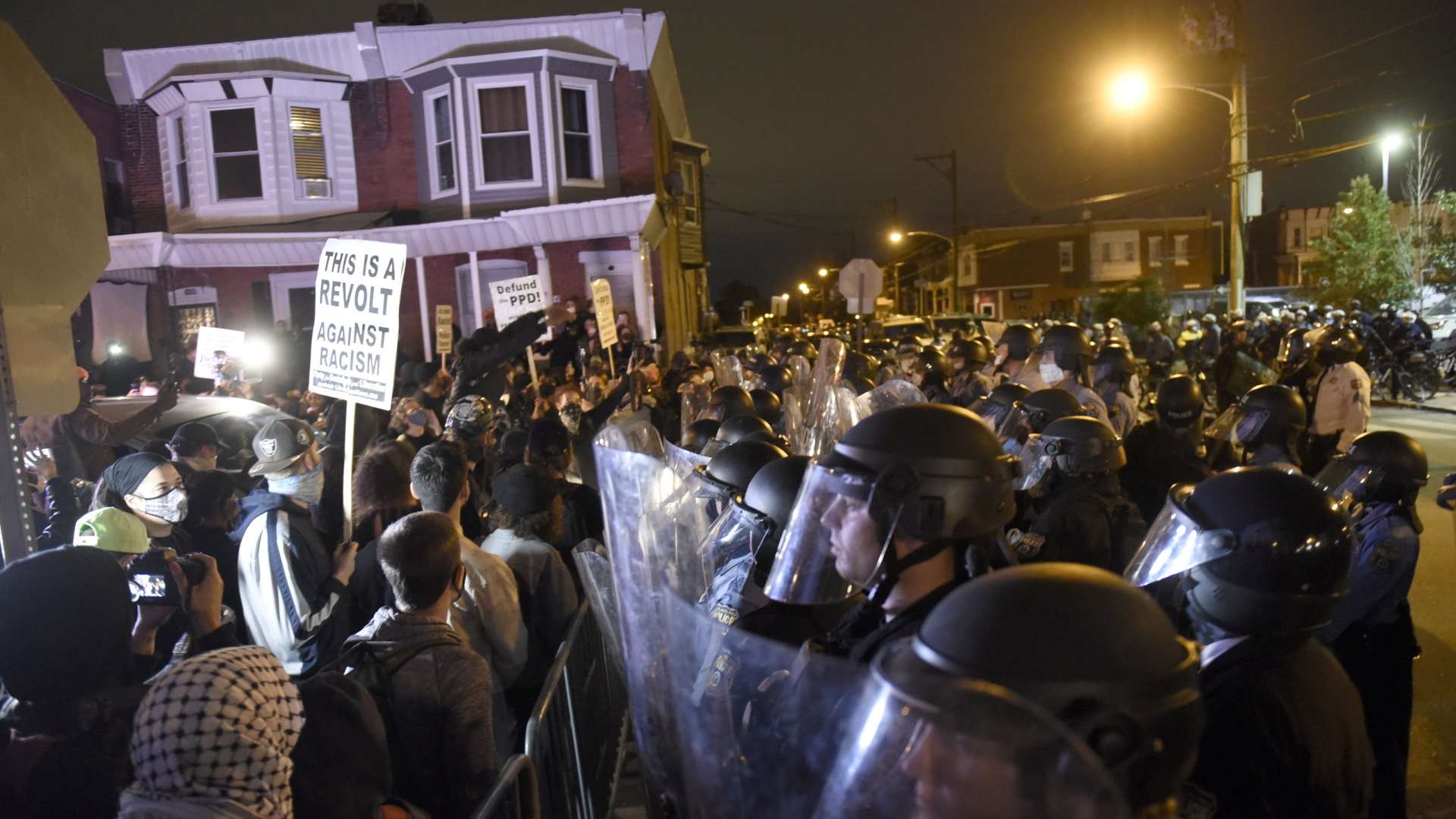 Hunderte Menschen protestieren inder Nacht in Philadelphia gegen Polizeigewalt und stehen Polizisten gegenüber. | AP