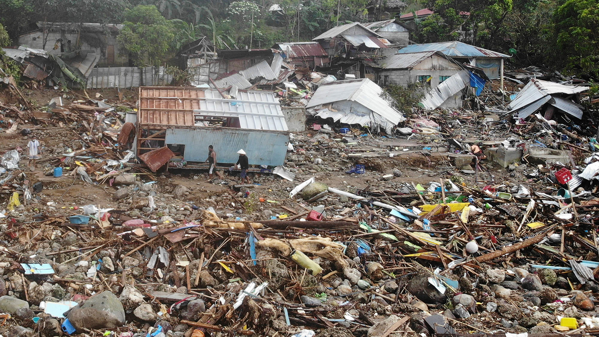 Eine Luftaufnahme zeigt Bewohner, die an zerstörten Häusern im Dorf Pilar in der Stadt Abuyog, Leyte, vorbeigehen.