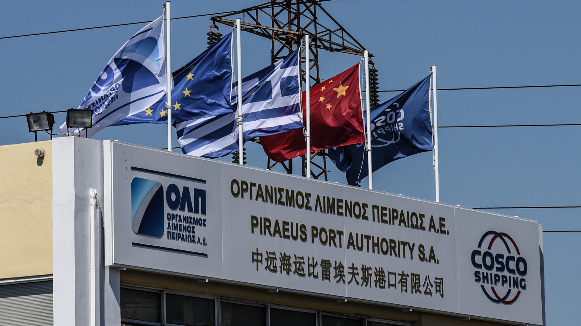 Das zentrale Bürogebäude von Piräus, beflaggt mit Fahnen der EU, Griechenlands und der Volksrepublik China. | picture alliance / NurPhoto