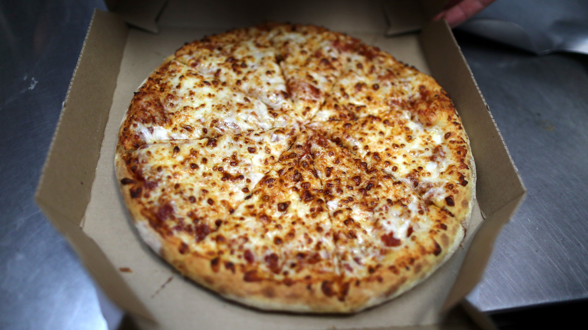 Eine Käsepizza liegt auf einem Pizzakarton. | REUTERS