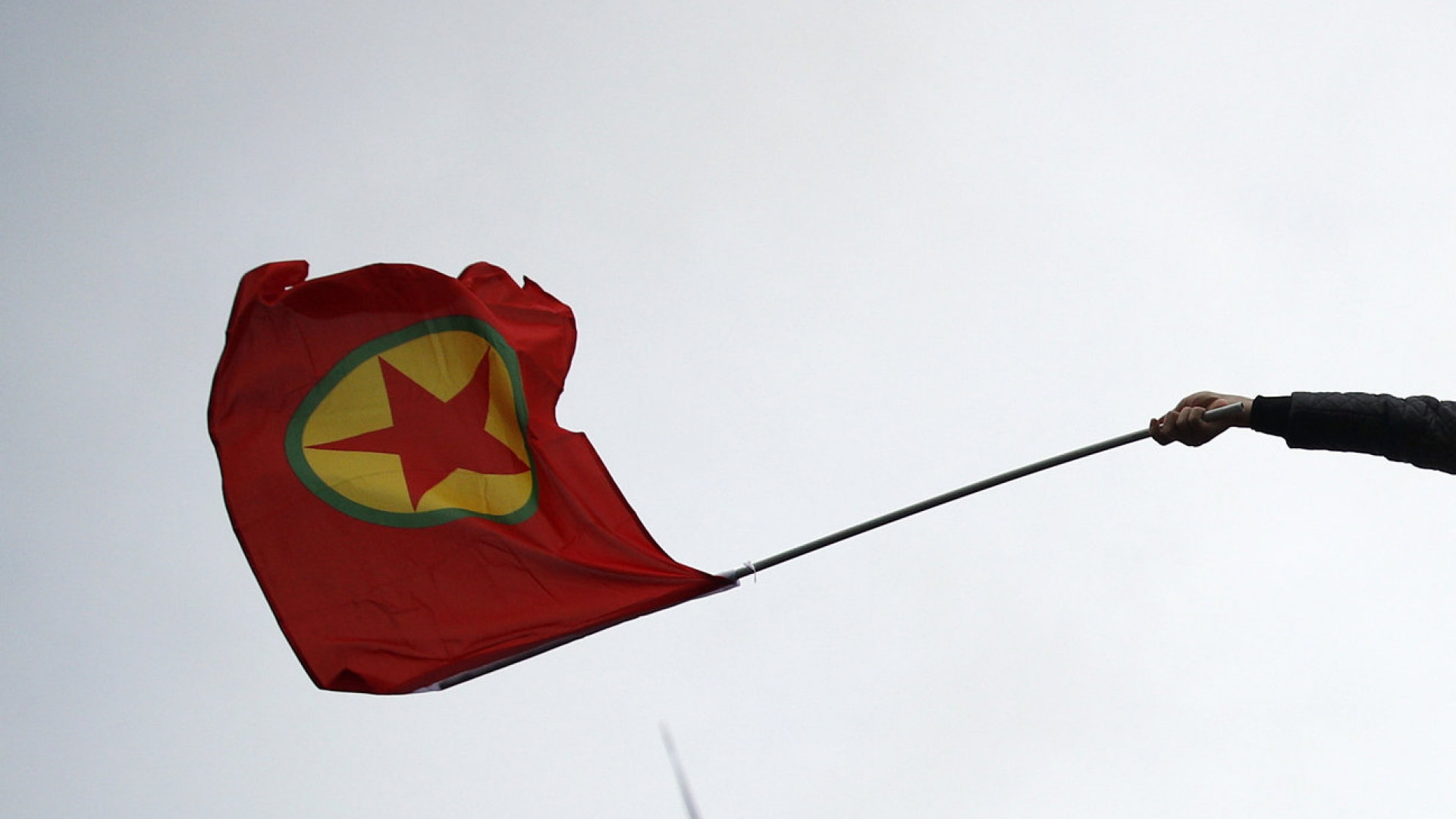 Ein Kurde schwenkt die Fahne mit dem Zeichen der PKK.
