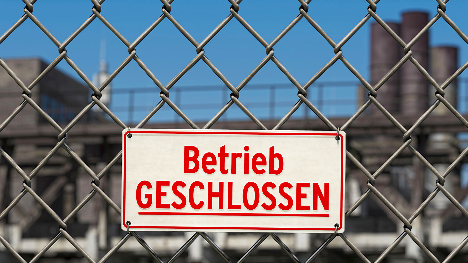 Schild mit der Aufschrift "Betrieb geschlossen", an einem Zaun vor einem Werksgelände. | picture alliance / Zoonar