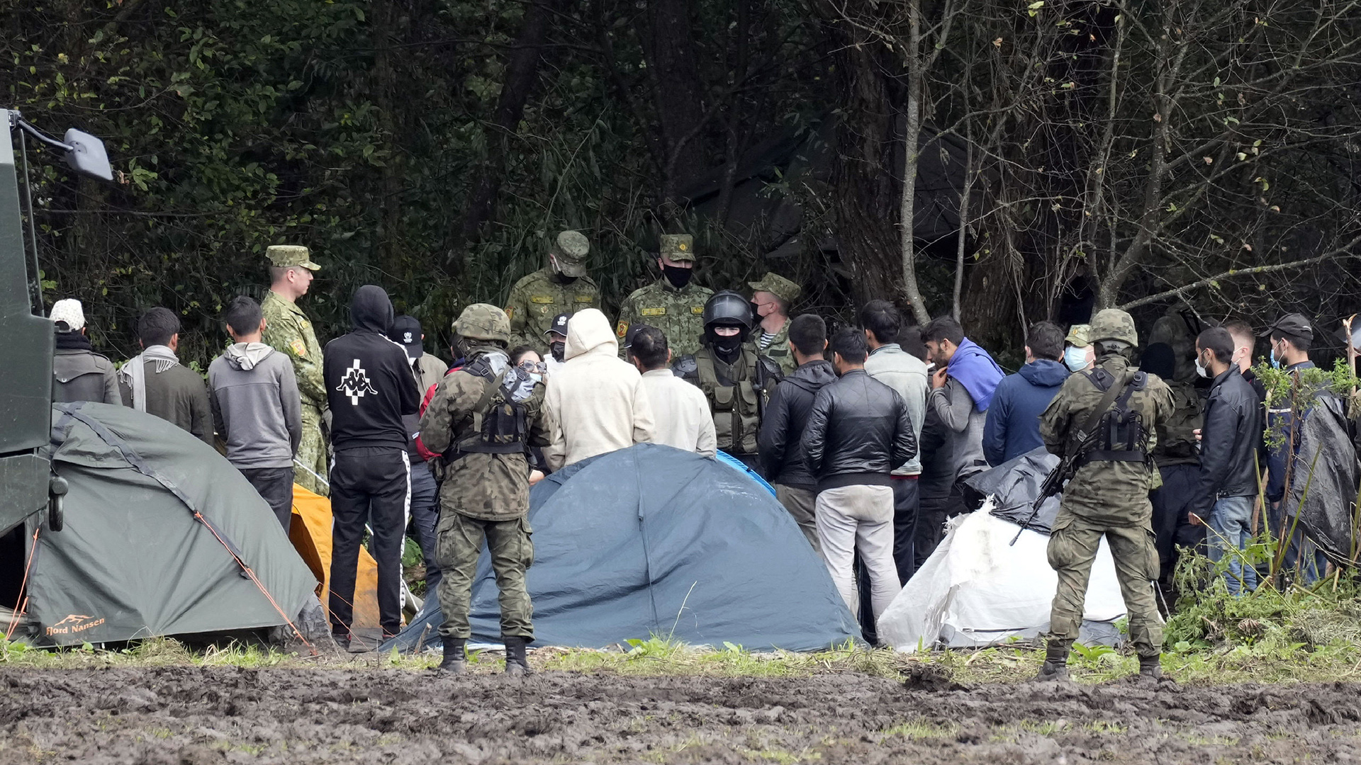 Polnische Sicherheitskräfte kontrollieren Flüchtlinge in einem Camp an der Grenze zwischen Polen und Belarus. | AP