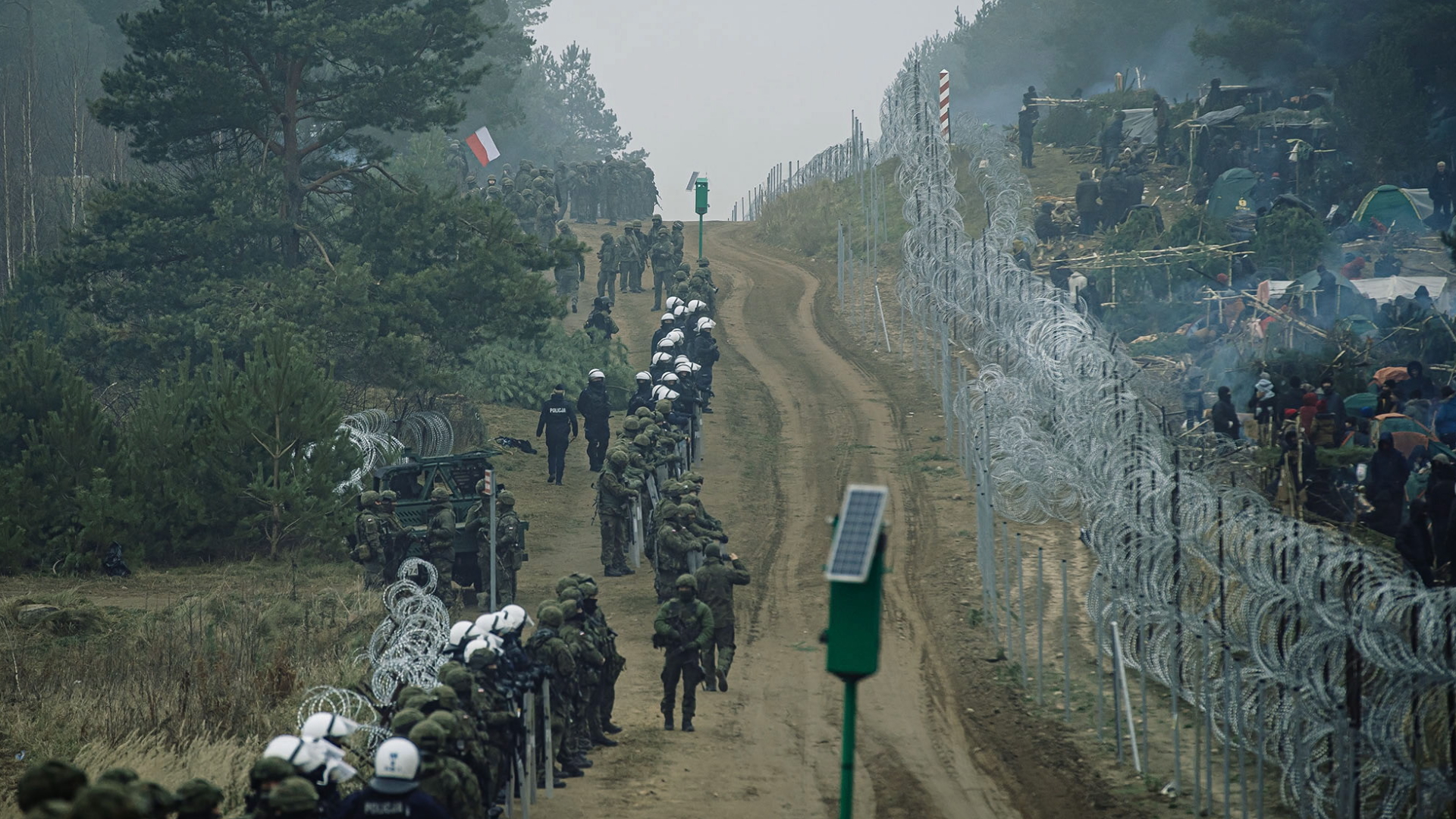 An der Grenze von Polen und Belarus trennt Stacheldraht polnische Grenzpolizei und Migranten | EPA