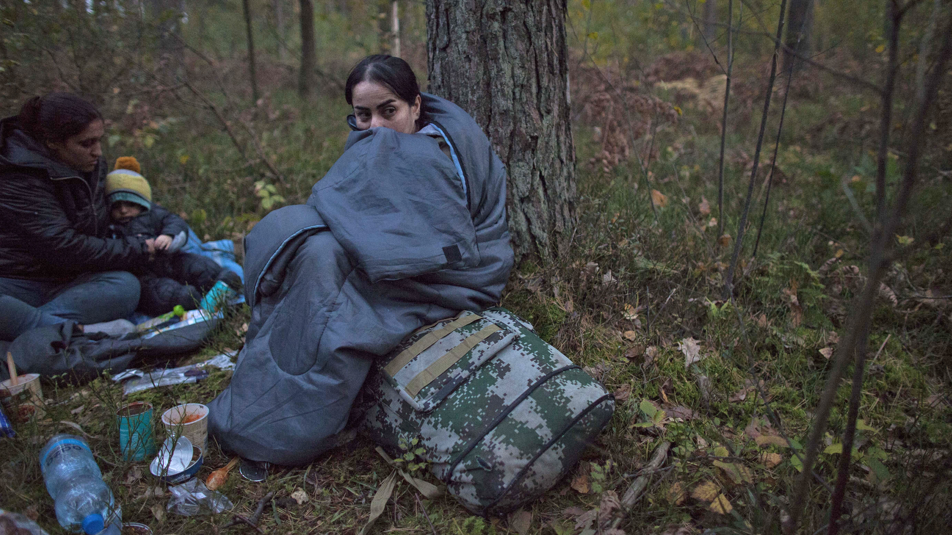Zwei Frauen und ein Kind mit Schlafsäcken im Wald an der polnisch-belarusischen Grenze | picture alliance / NurPhoto