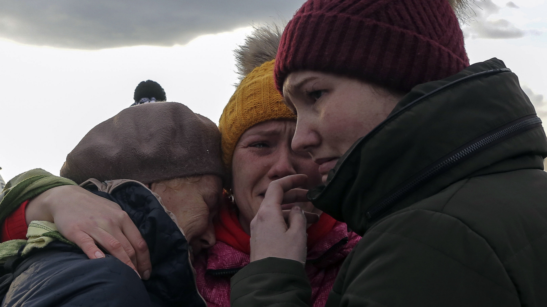 Drei Ukrainerinnen umarmen sich auf der polnischen Seite der Grenze. | AP