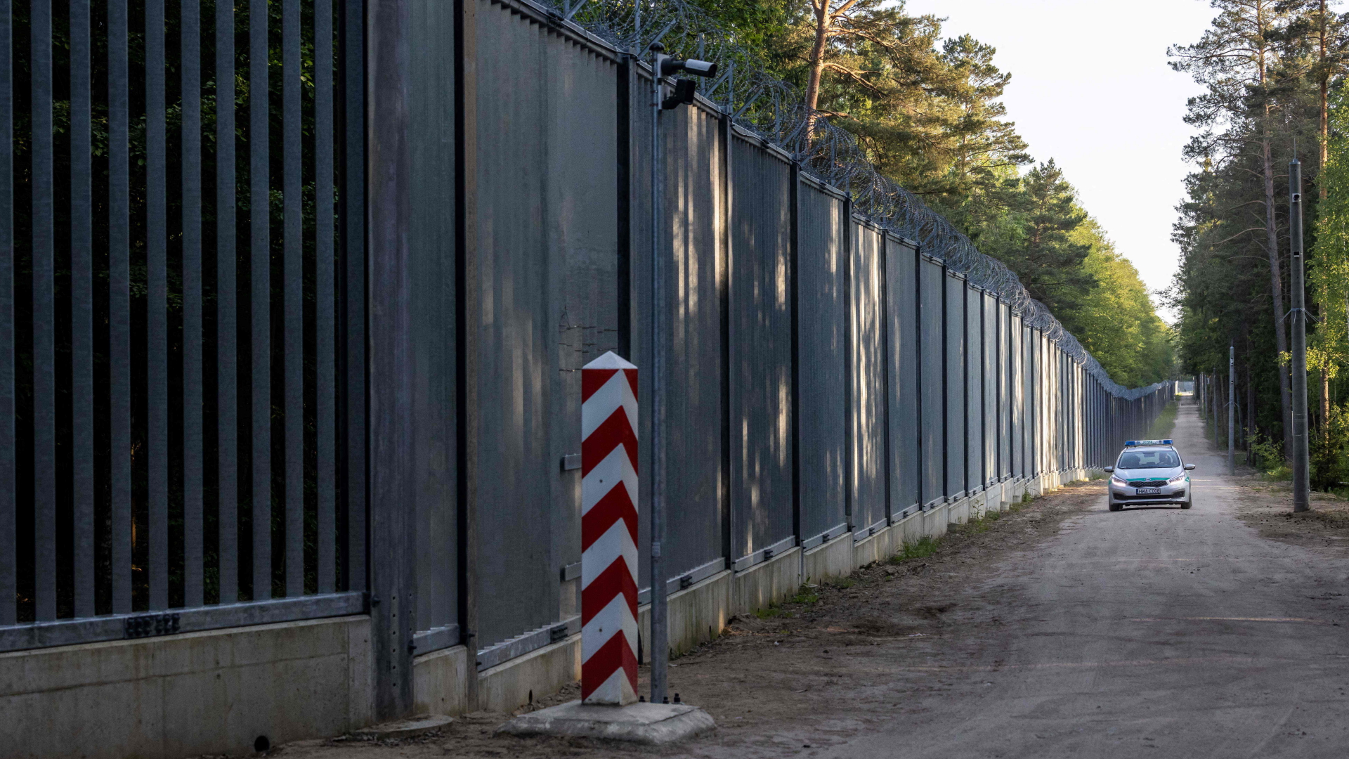 Ein Fahrzeug der Polizei kontrolliert am Grenzzaun zwischen Polen und Belarus in Bialowieza