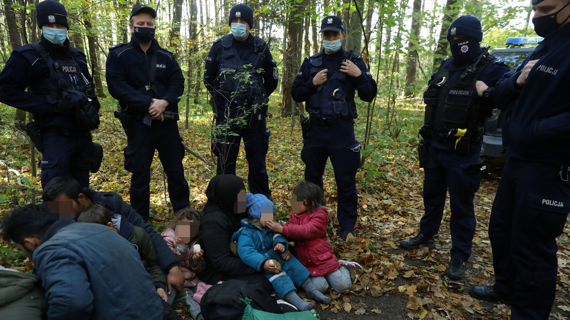 Eine Gruppe von Migranten aus dem Irak ist im polnisch-belarusischen Grenzgebiet bei Hajnowka umstellt von polnischen Polizisten. | REUTERS