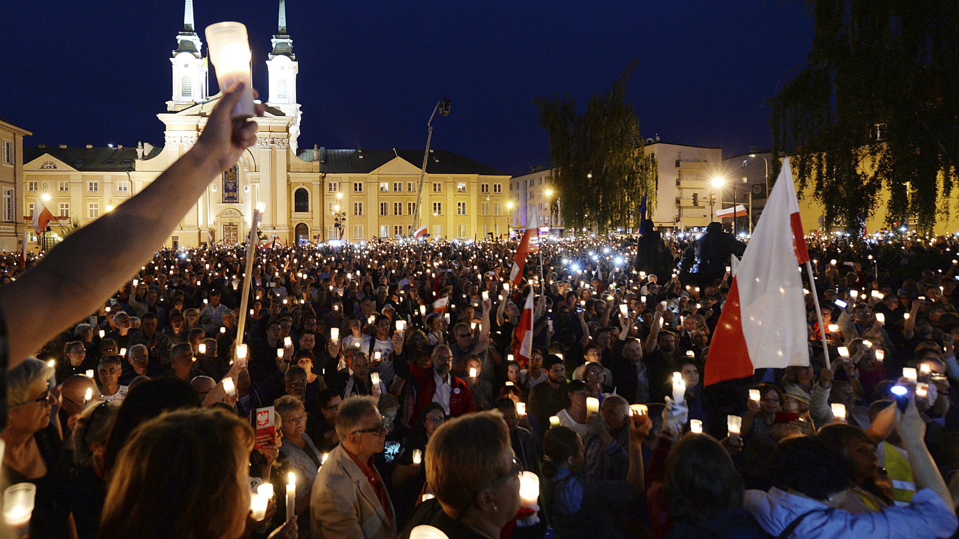 Tausende Demonstranten halten auf dem Platz vor dem Obersten Gerichtshof in Warschau als Zeichen des Protests Kerzen in die Höhe. | dpa