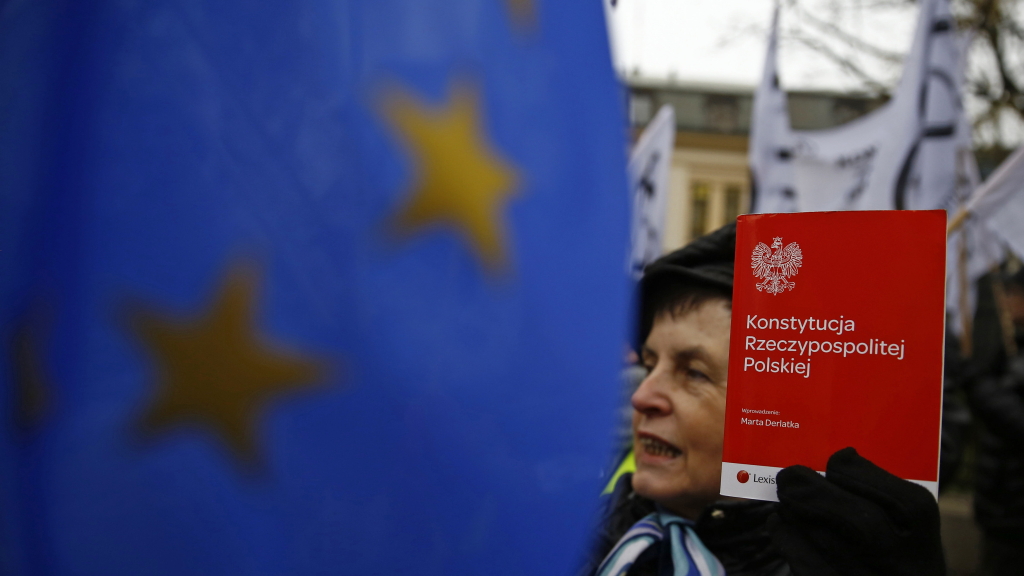 Eine Demonstrantin in Warschau hält die polnische Verfassung hoch.