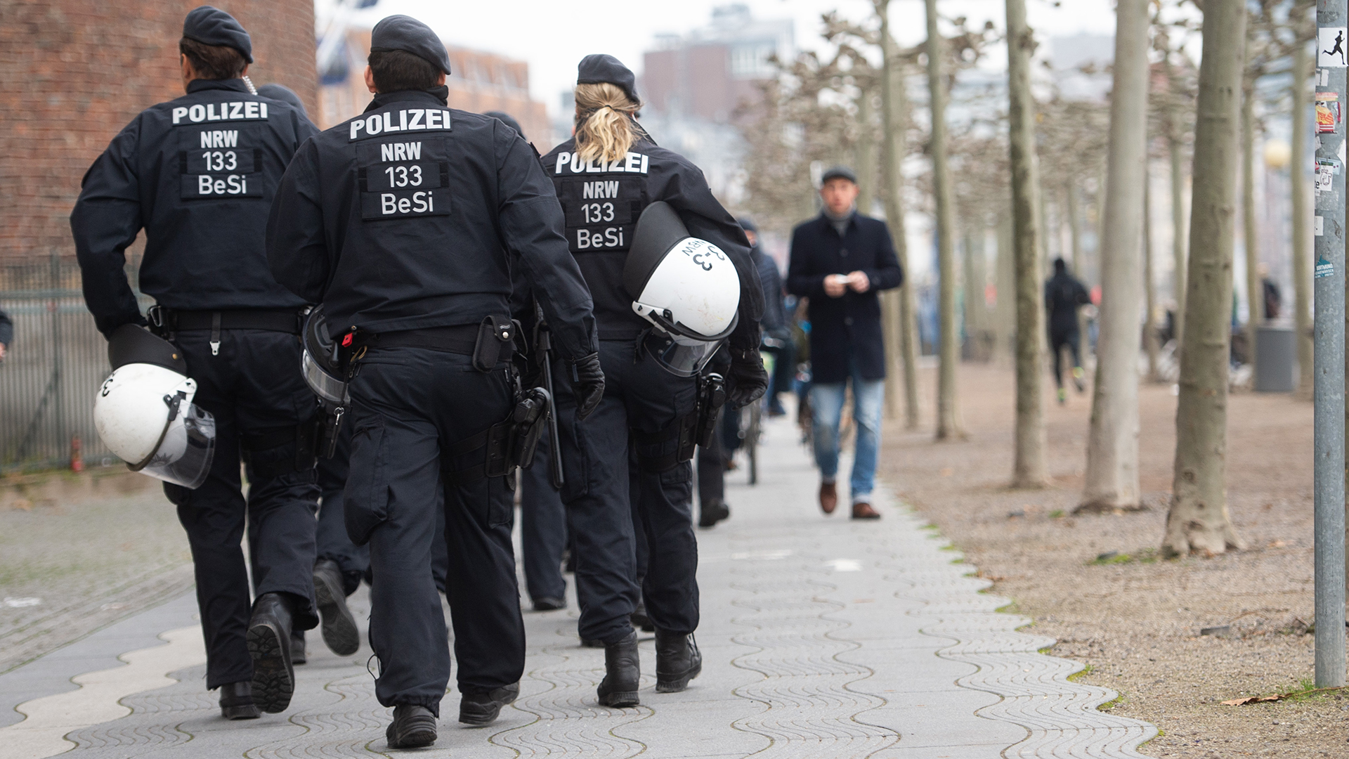 Polizisten gehen am Rheinufer entlang.