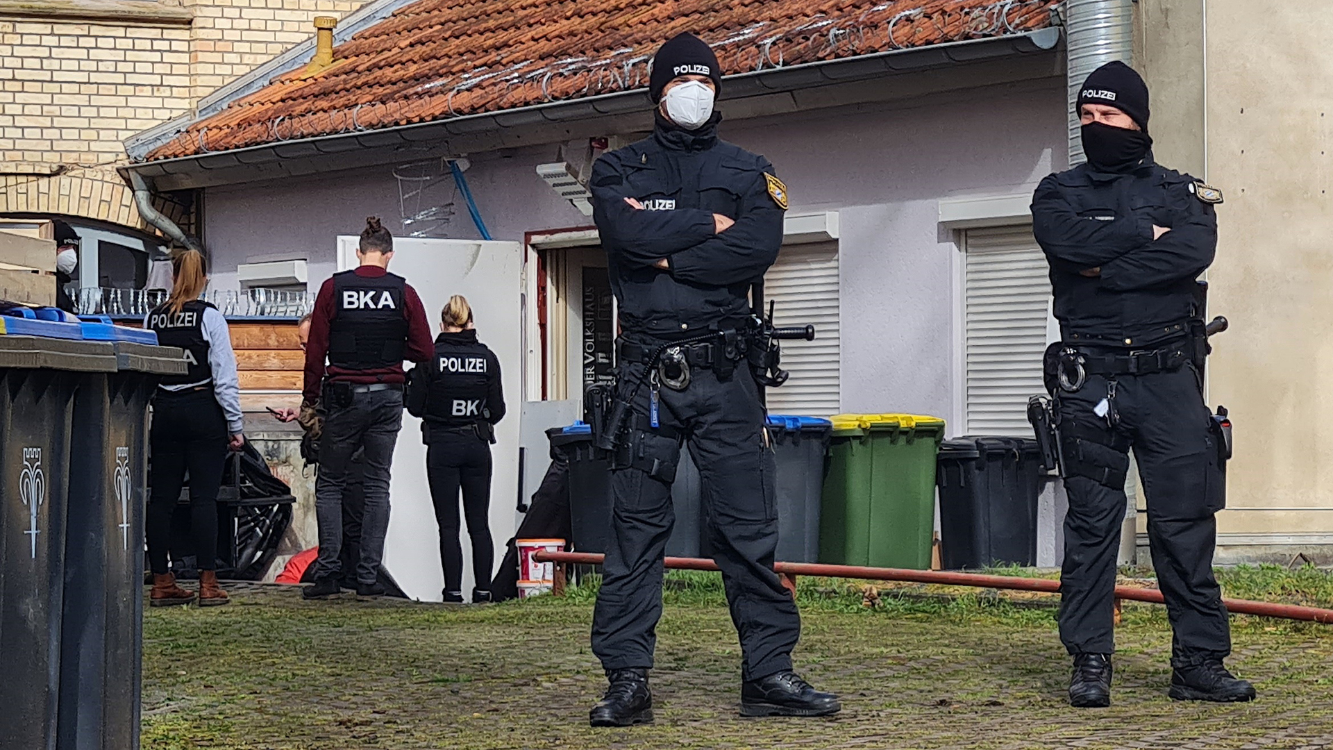 Polizisten stehen vor einem Hintereingang eines Gebäudes in Eisenach. | dpa