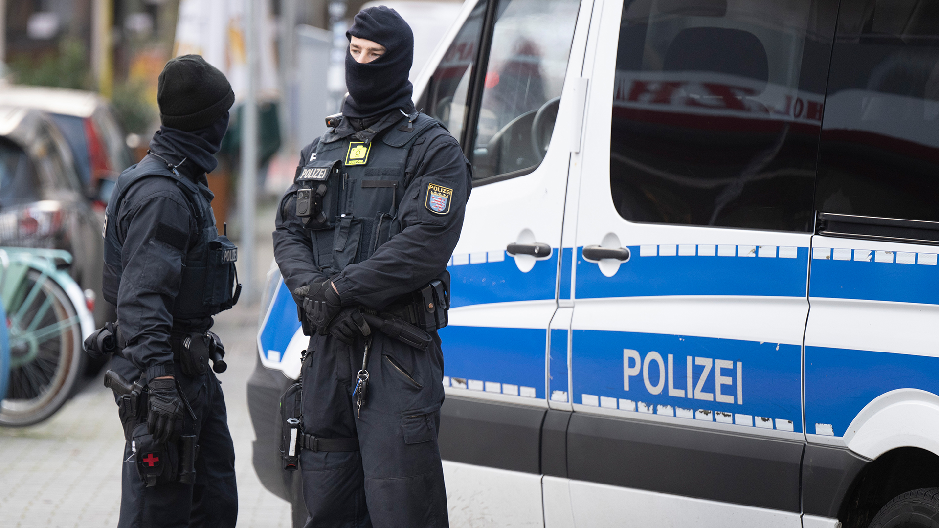 Bei einer Razzia gegen sogenannte Reichsbürge stehen Polizisten an einem durchsuchten Objekt in Frankfurt.