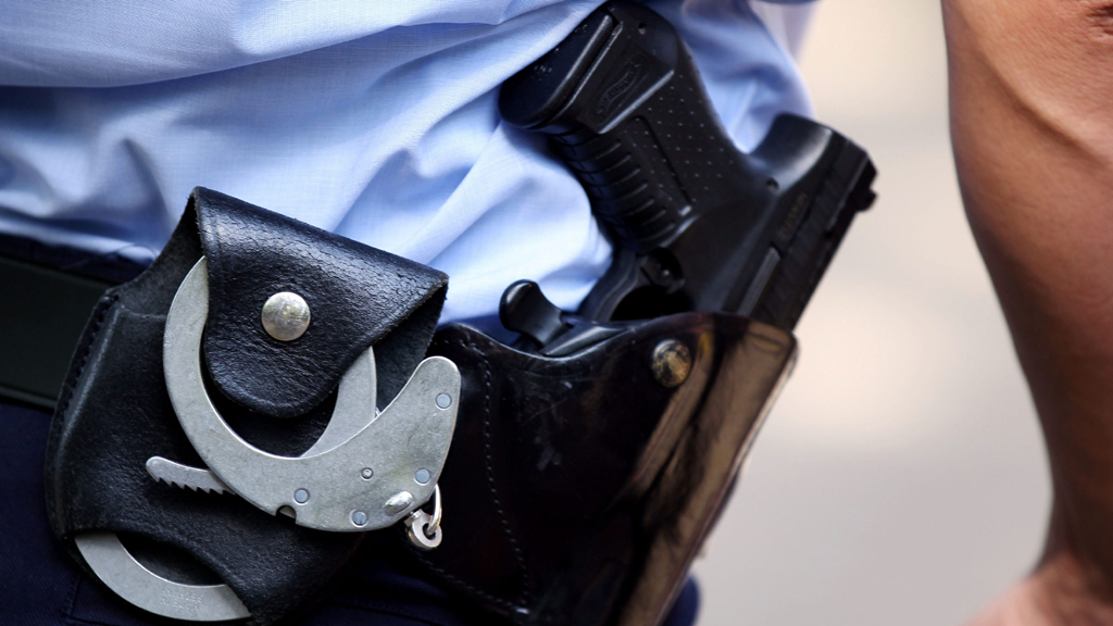 Ein Polizist mit Handschellen und Pistole am Gürtel