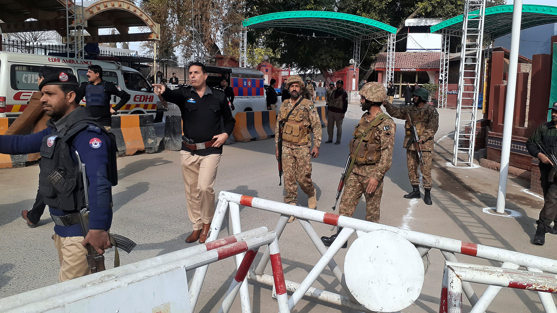 Soldaten der Armee und Polizeibeamte machen den Weg für Krankenwagen frei, die zu einer Bombenexplosion am Haupteingang der Polizeibehörde in Peshawar (Pakistan). | AP