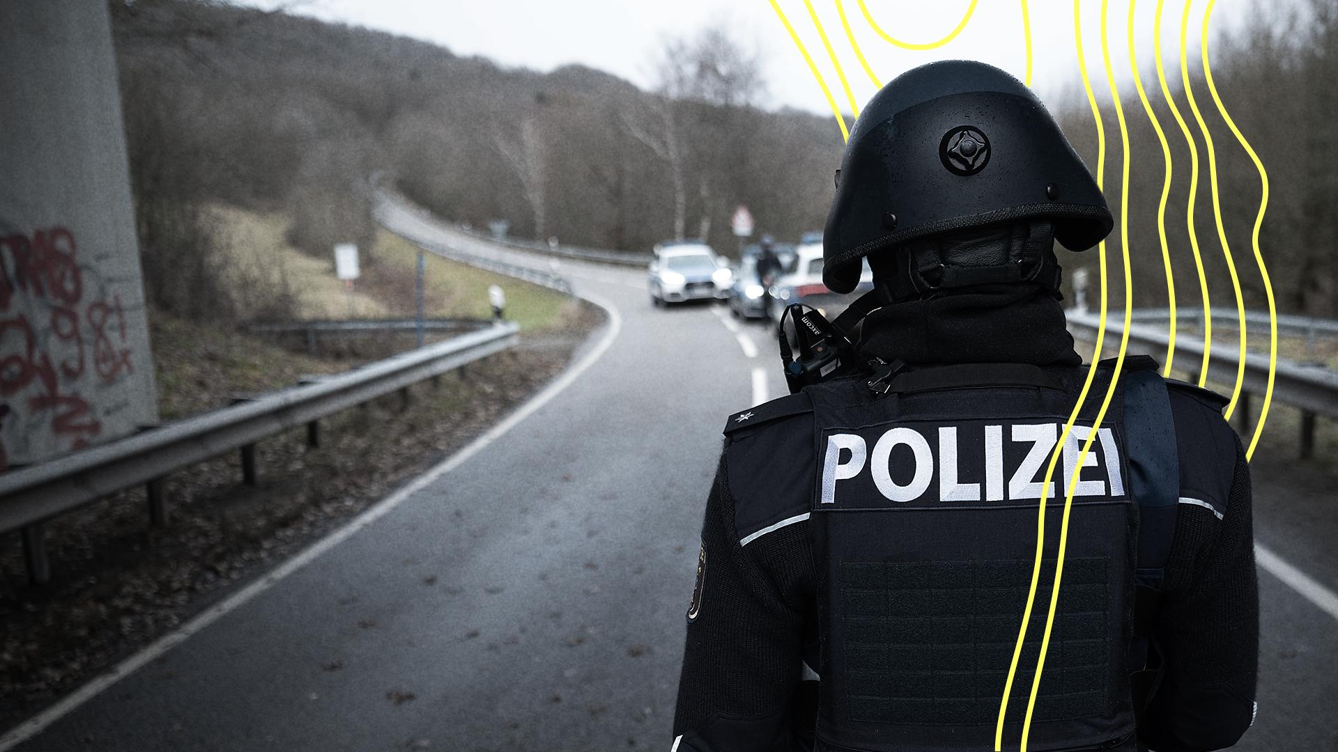 Ein Polizist in Schutzkleidung von hinten. | Picture alliance/dpa / Sebastian Gollnow