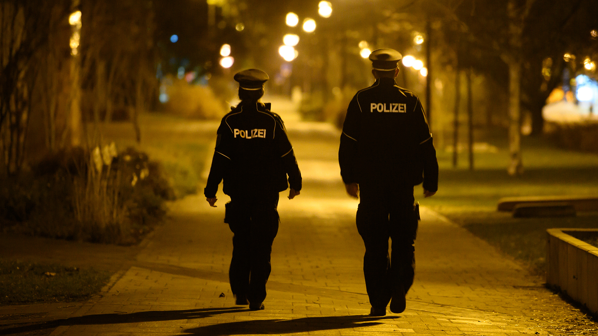 Polizisten laufen in der Nacht im Stadtteil Gorbitz Streife und kontrollieren die Einhaltung der Ausgangssperre.