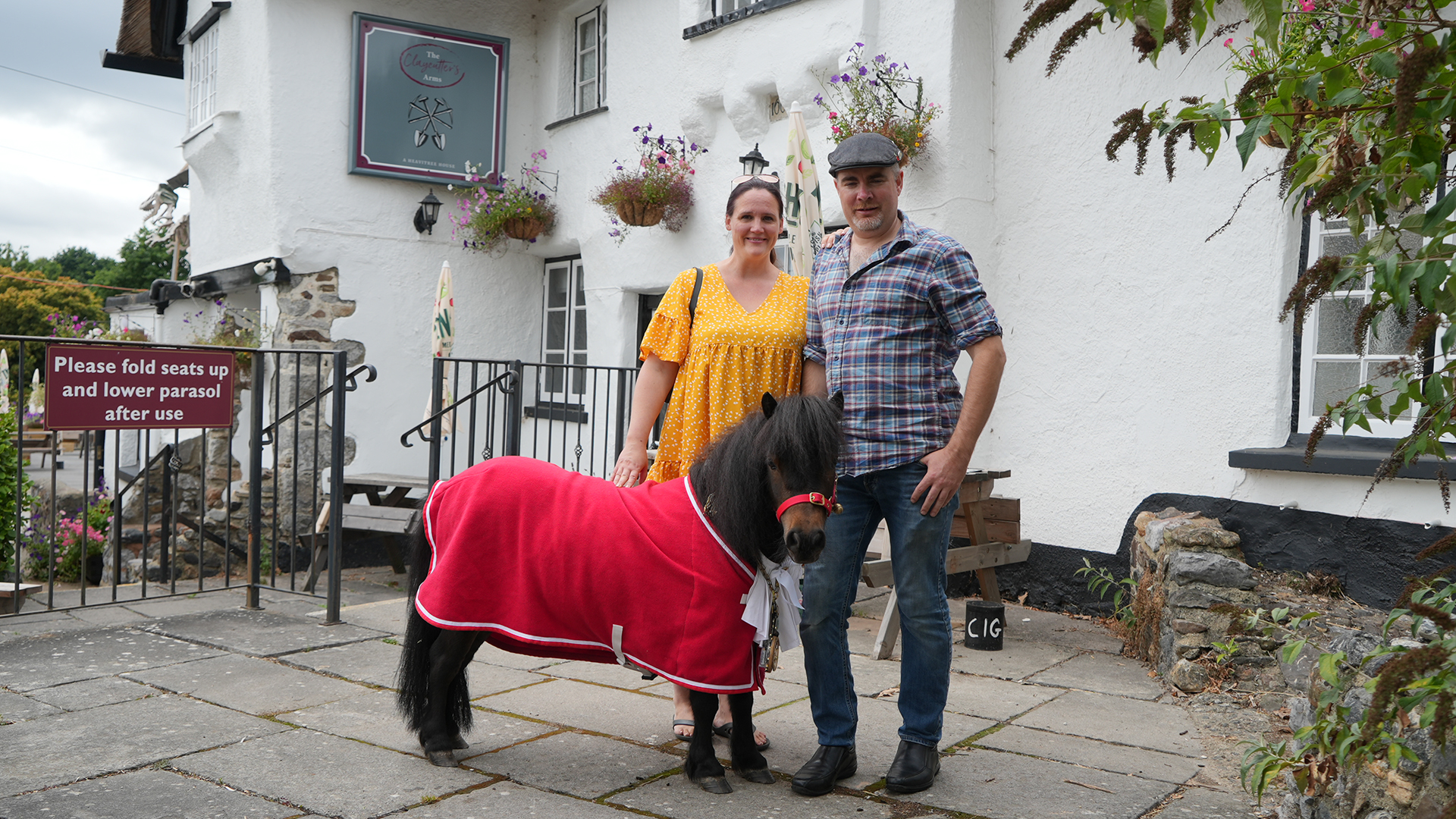 Pony Patrick und sein Besitzer Kirk und Hannah Petrakis stehen vor einem Haus. | Erik Haasdonk