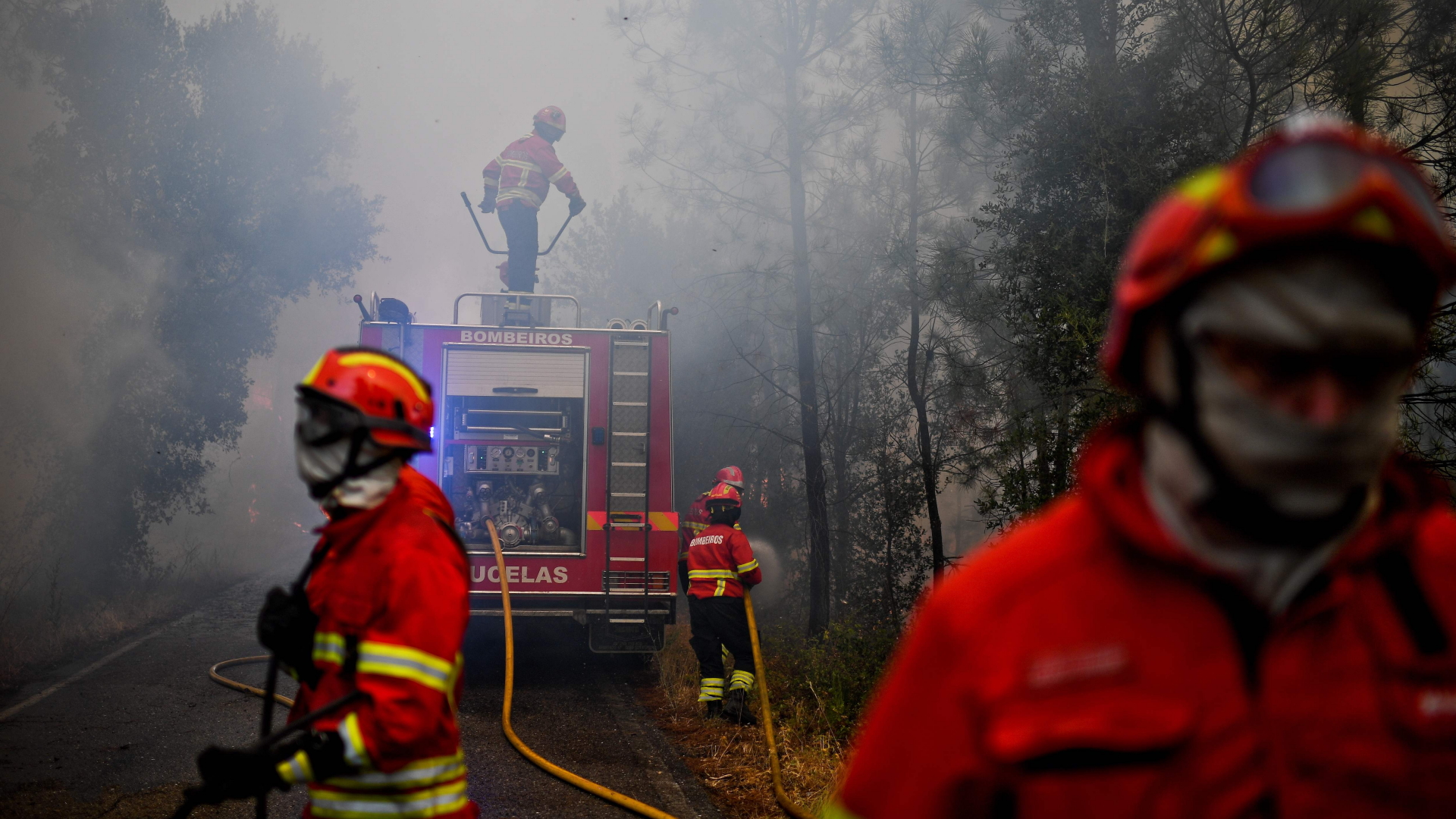 Feuerwehrmänner kämpfen im dichten Qualm gegen die Flammen. | AFP
