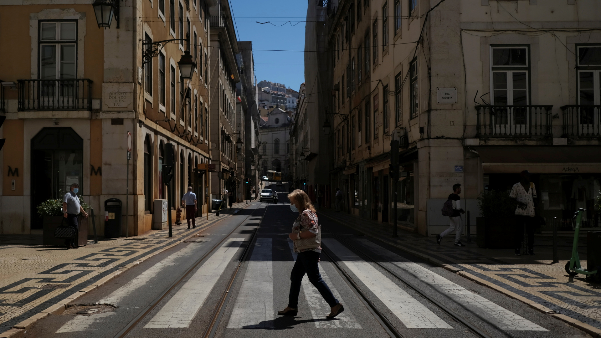 Eine Frau geht in der portugiesischen Stadt Lissabon über eine Straße (Archivbild). | REUTERS