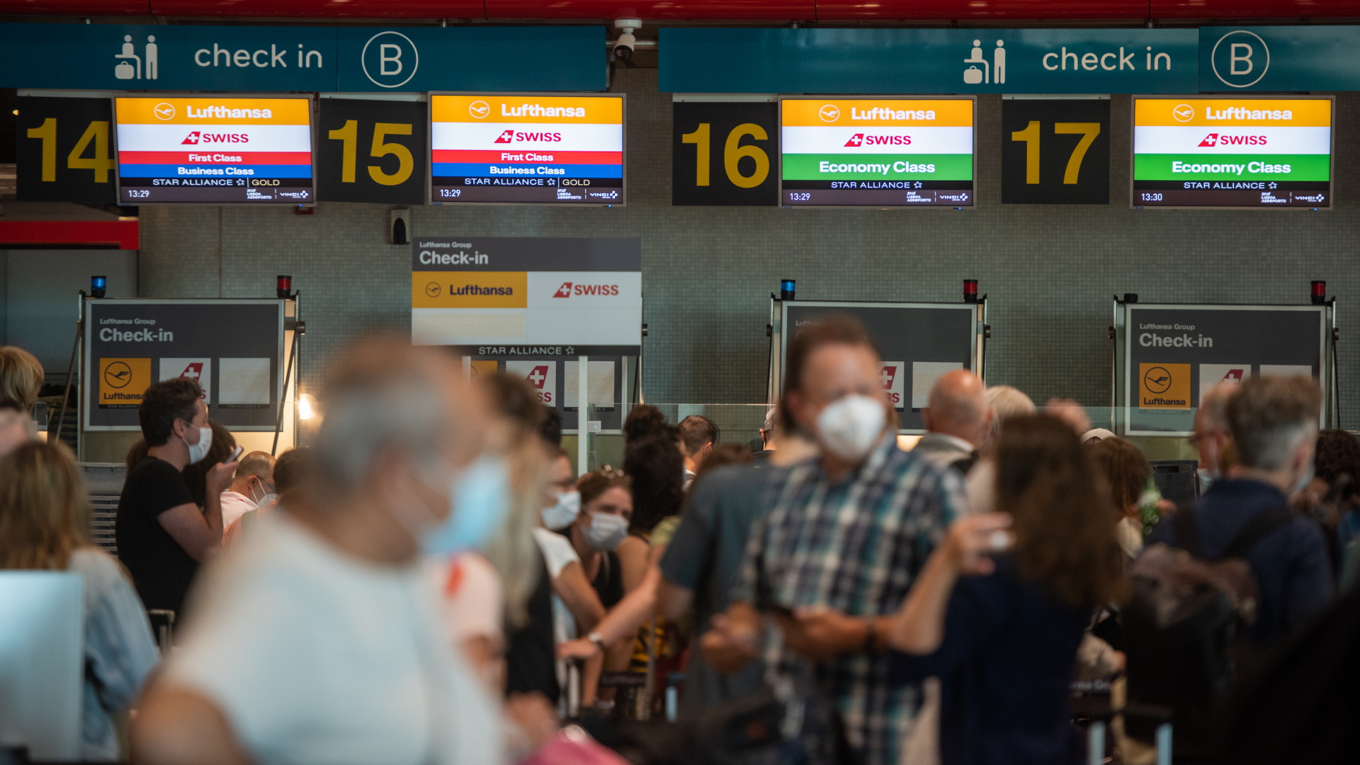 Zahlreiche Passagiere mit Corona-Schutzmasken stehen auf dem Flughafen in Lissabon Ende Juni 2021 Schlange vor einem Check-In-Schalter. | dpa
