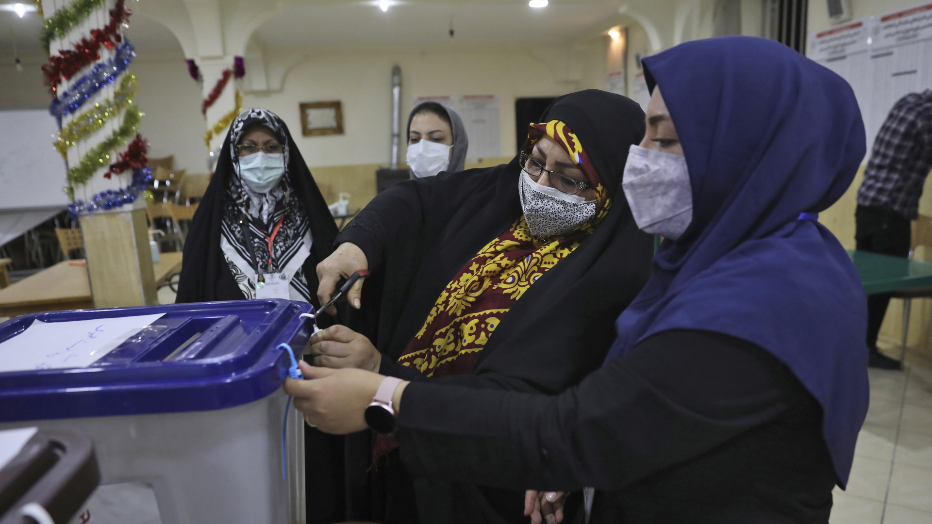 Frauen öffnen zur Auszählung eine Kiste mit Stimmzetteln | AP