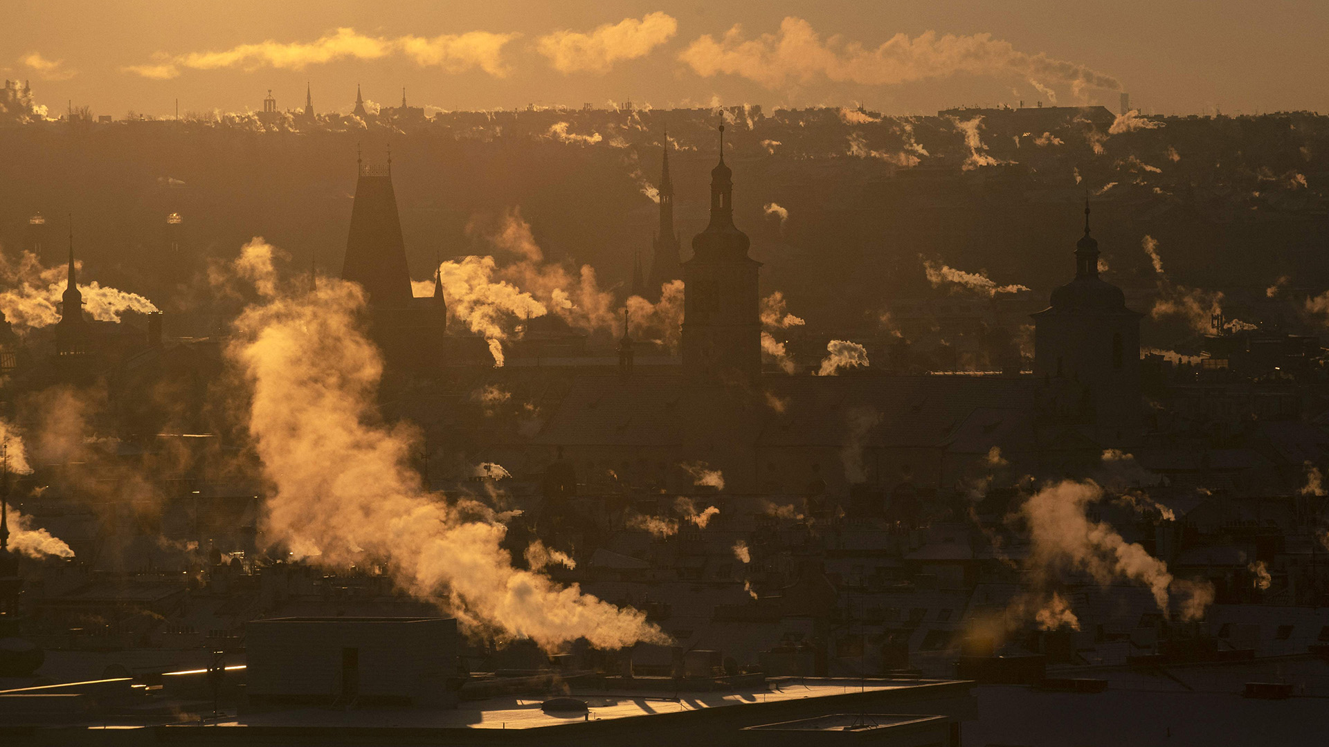 Rauch aus Schornsteinen über den Dächern von Prag während des Sonnenaufgangs. | AFP