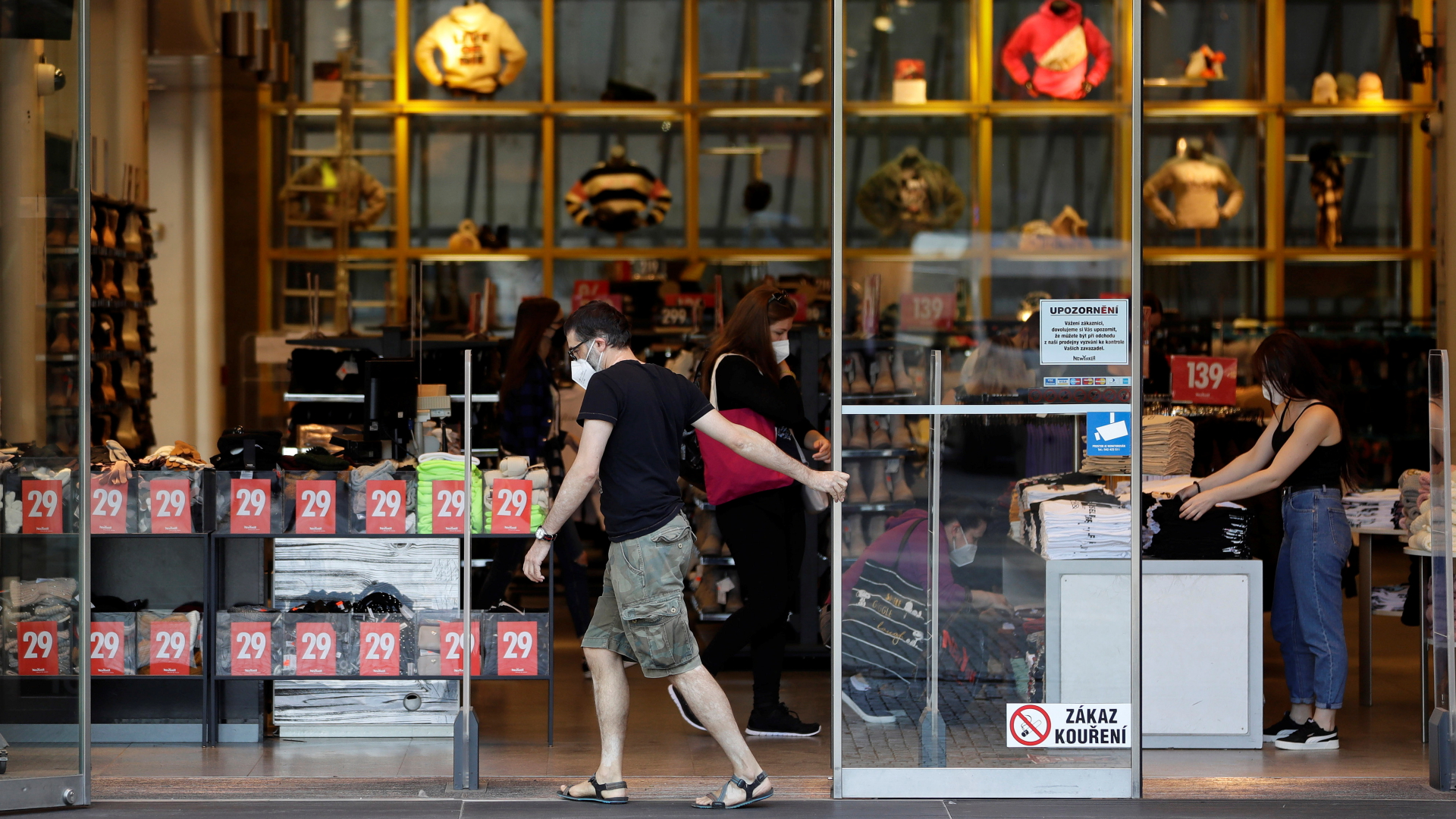 Ein Mitarbeiter öffnet die Glastüren eines Geschäfts in Prag. | REUTERS