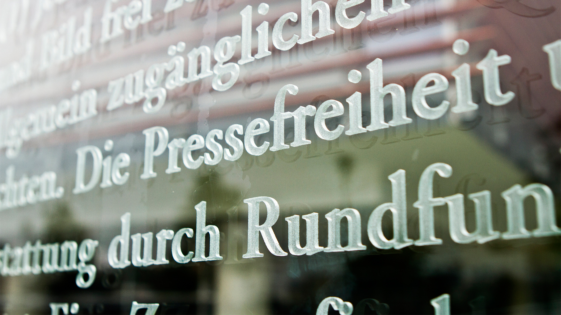 Das Wort Pressefreiheit ist in einem Ausschnitt des Artikels 5 des Grundgesetzes auf einer Glasscheiben am Außenhof des Jakob-Kaiser-Hauses zu sehen.