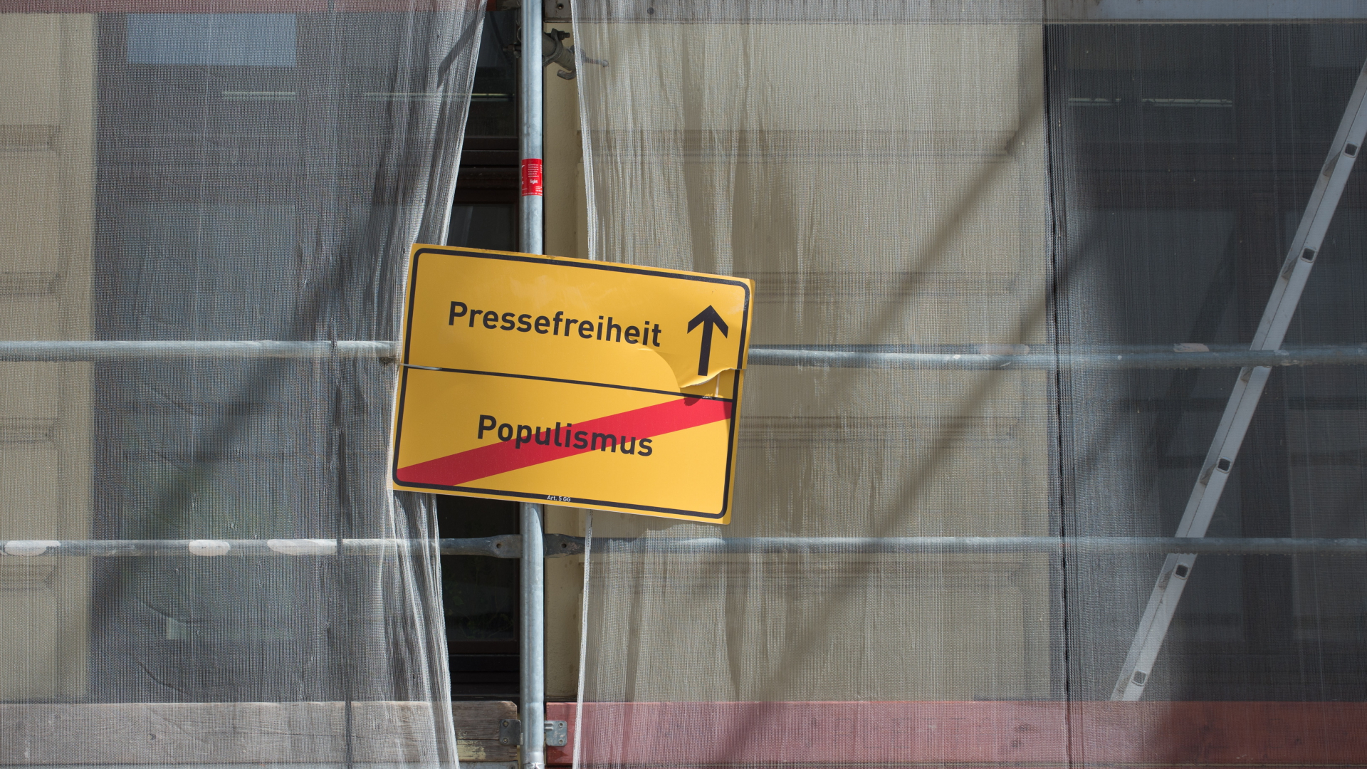 Die Worte "Pressefreiheit" und "Populismus" stehen auf einem Schild, das an einem Baugerüst angebracht ist.  | dpa