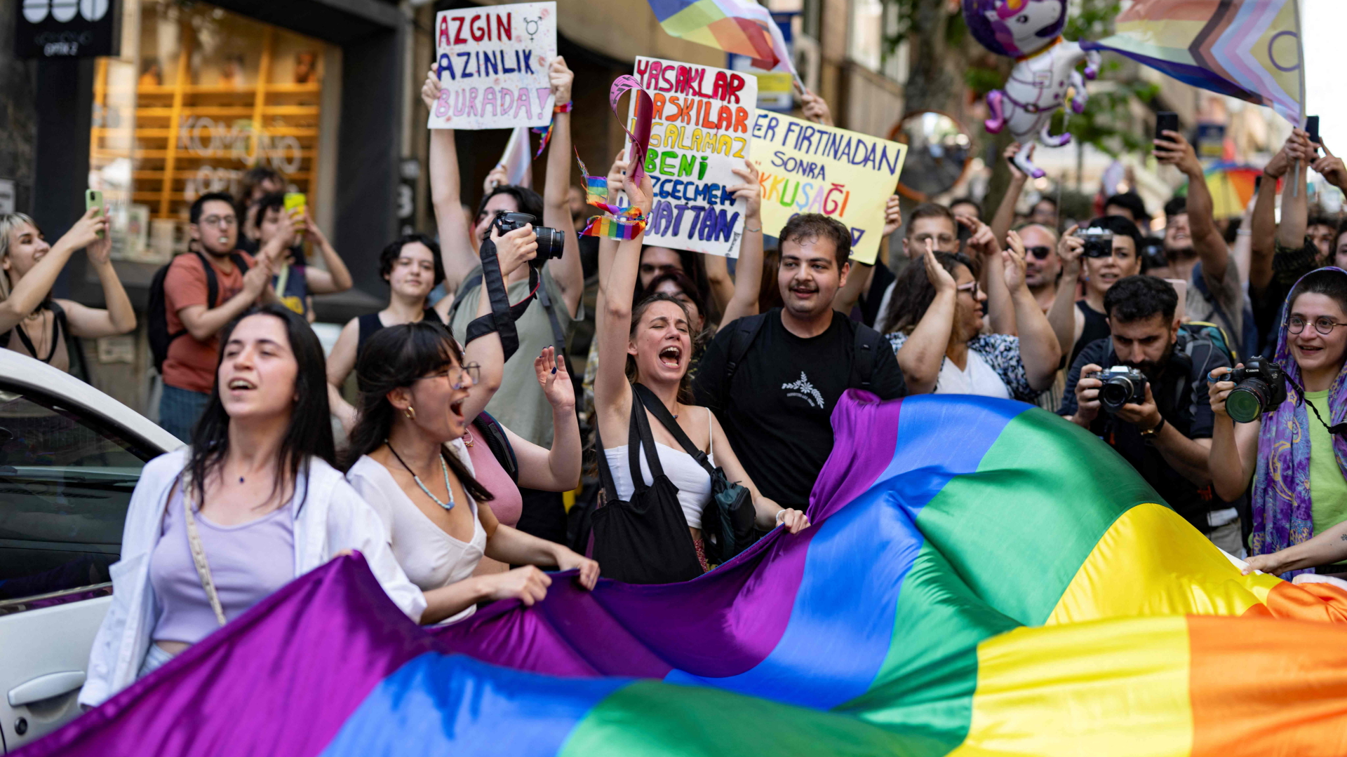 Mitglieder und Unterstützer der LGBTQ-Community halten während des nicht genehmigten Pride-Marsches in Istanbul am 25. Juni 2023 regenbogenfarbene Flaggen.