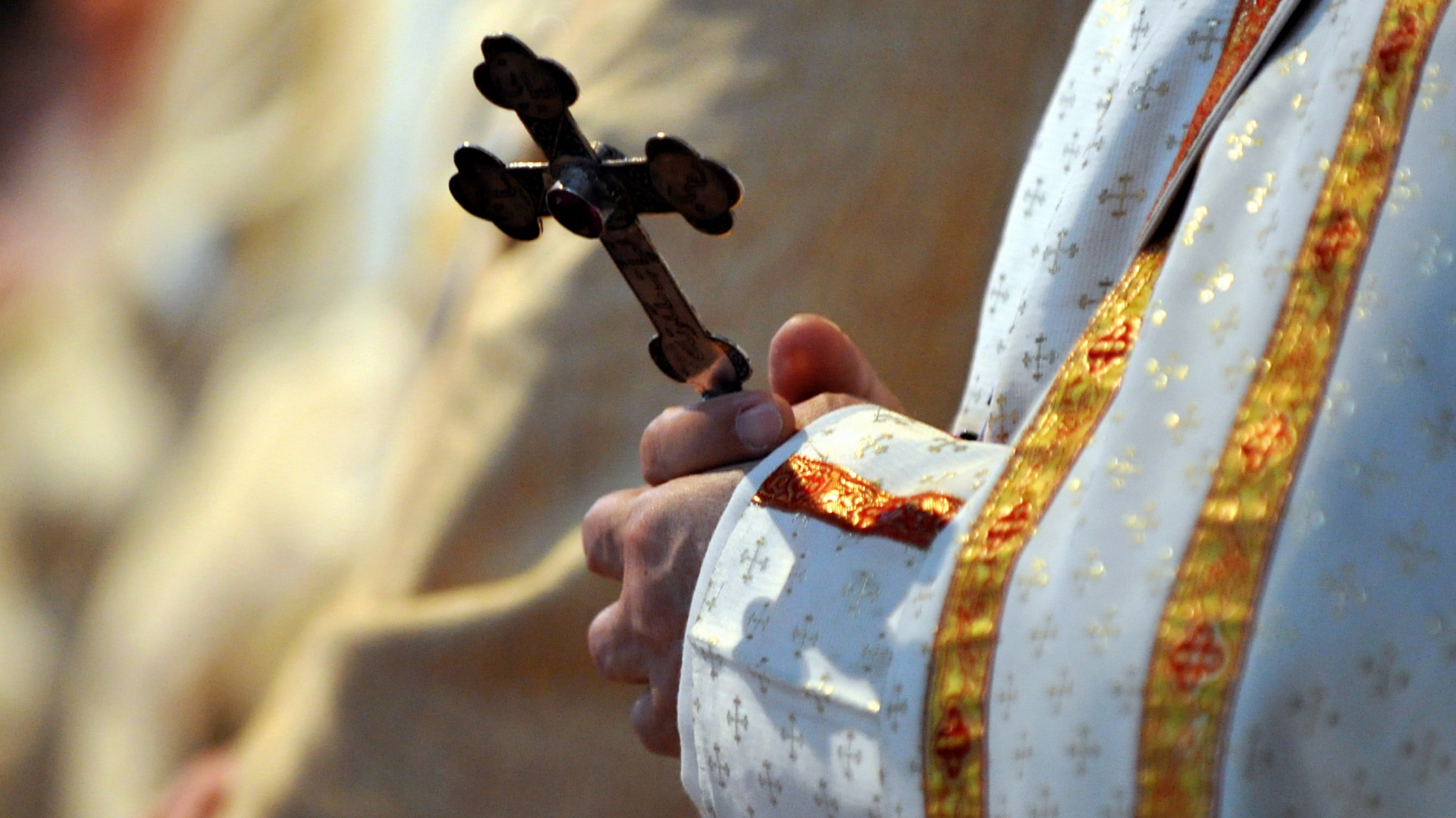 Ein Bischof hält während einer katholischen Messe in der Münchner Sankt Paul Kirche ein Kreuz in den Händen | dpa