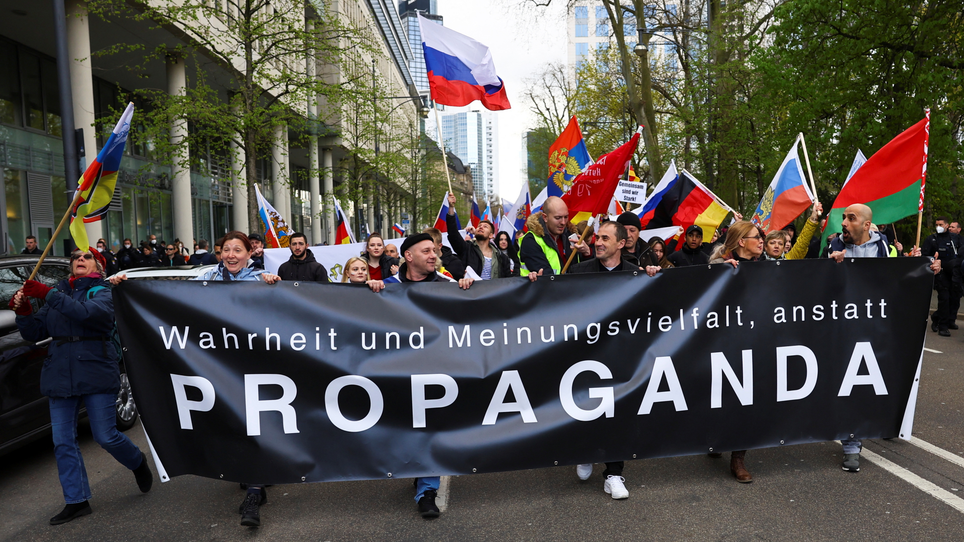 Teilnehmer einer russischen Unterstützerdemonstration tragen ein Transparent, auf dem steht "Wahrheit und Meinungsvielfalt anstatt Propagand