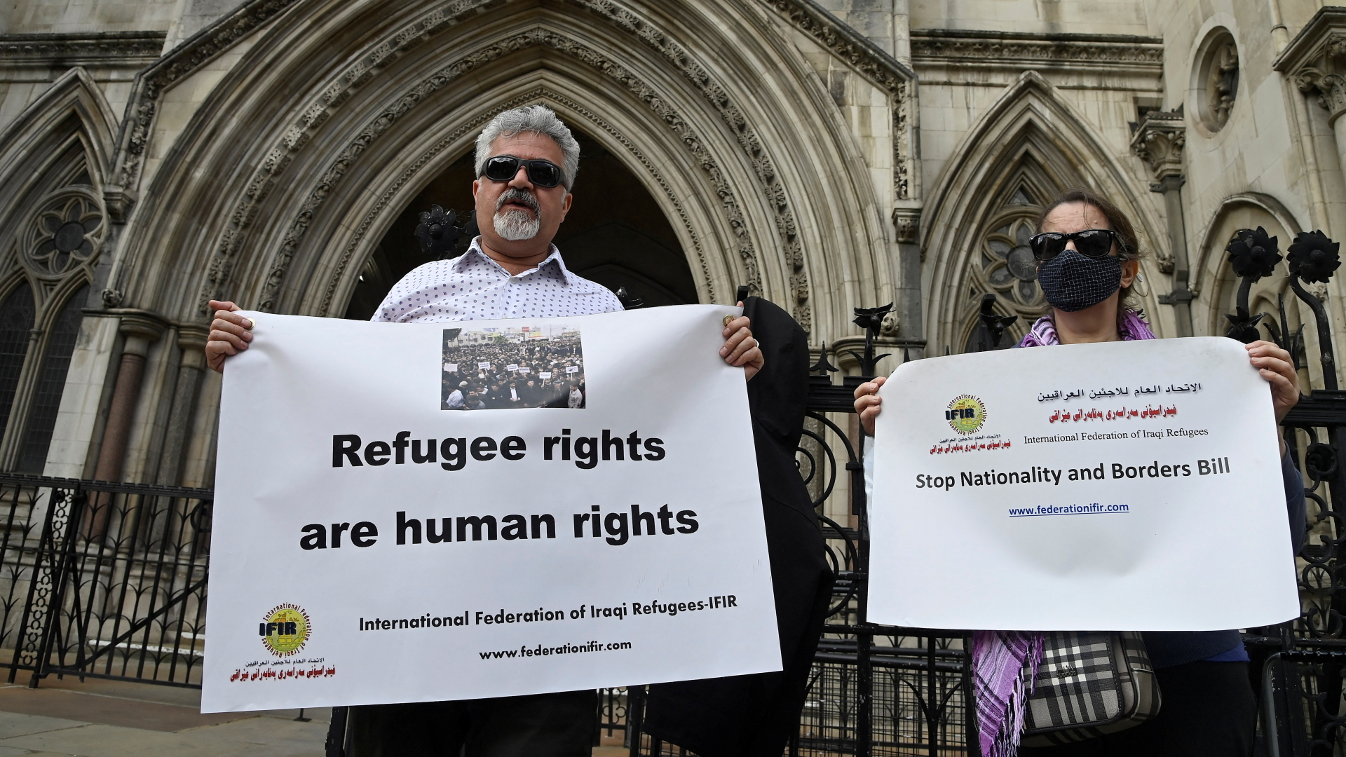 Zwei Personen mit Transparenten protestieren in London gegen geplante Abschiebeflüge der britischen Regierung.  | REUTERS