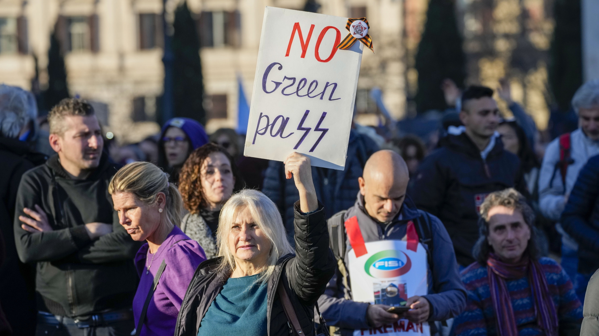 Eine Frau hält bei einer Demonstration in Rom ein Schild gegen den "Green Pass" hoch. | AP