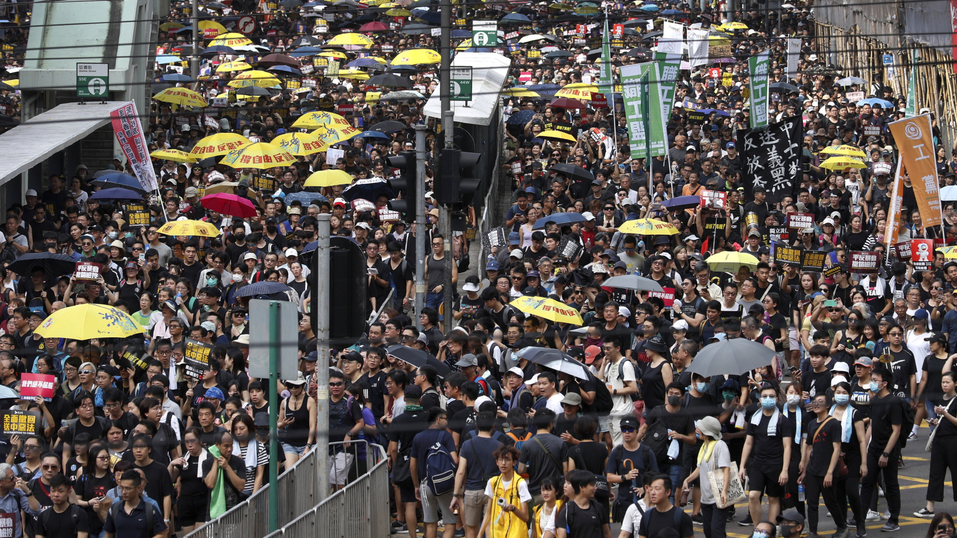 Demonstranten halten Plakate und Regenschirme, während sie an einem Protestmarsch 2019 in Hongkong teilnehmen. | dpa