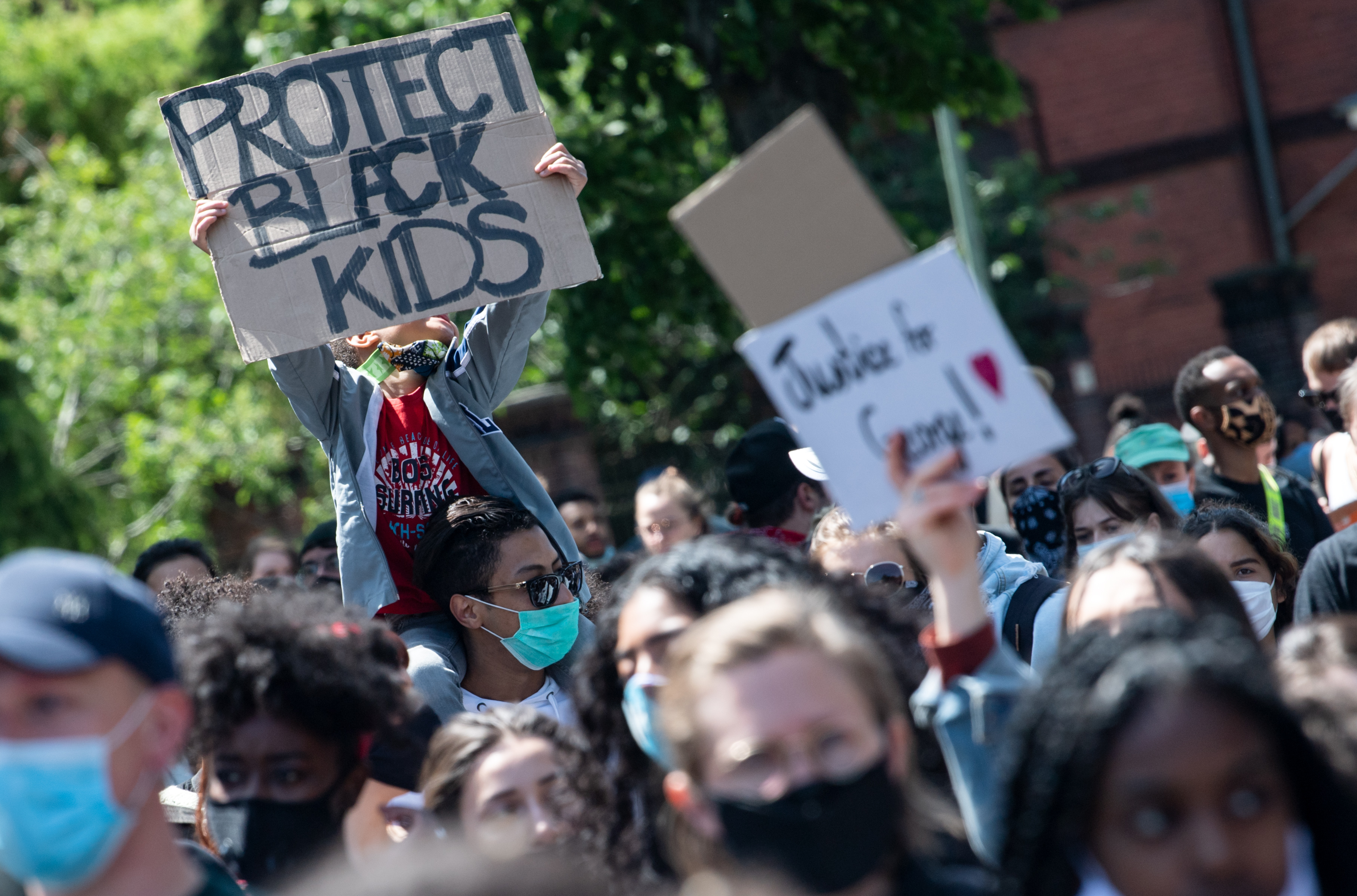 Demonstranten protestieren in Kreuzberg nach dem gewaltsamen Tod von George Floyd durch einen weißen Polizisten in den USA gegen Rassismus und Polizeigewalt, u.a. mit einem Schild "Protect black kids" | dpa