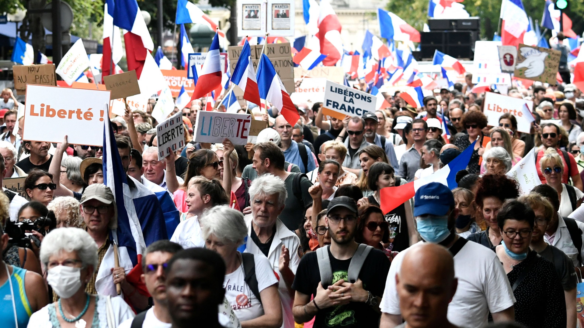 Demonstranten in Paris schwenken französische Flaggen und halten Schilder mit der Aufschrift "Liberté"  und "Libérons La France" - hoch. | AFP