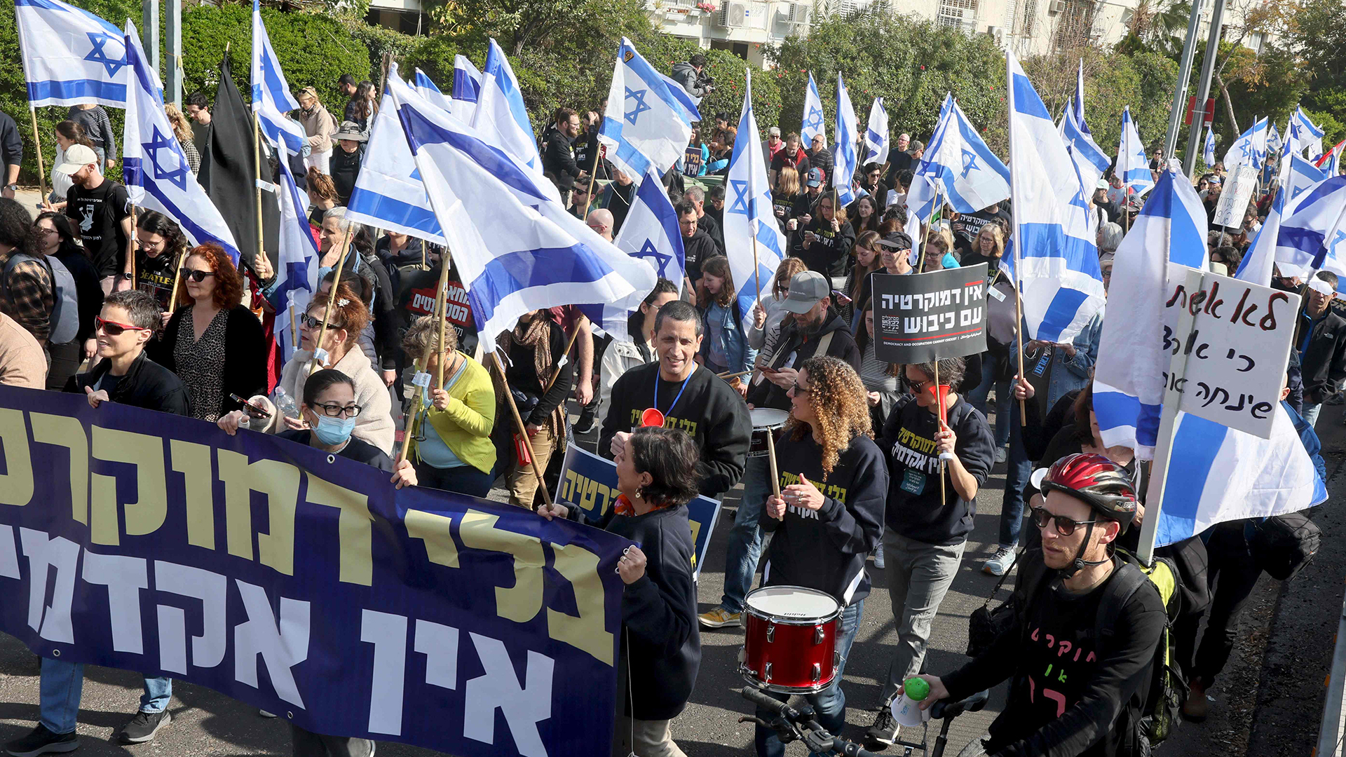 Israelische Demonstranten halten Nationalflaggen und Plakate hoch, während sie in Tel Aviv an einer Demonstration gegen die umstrittenen Rechtsreformen teilnehmen. | AFP